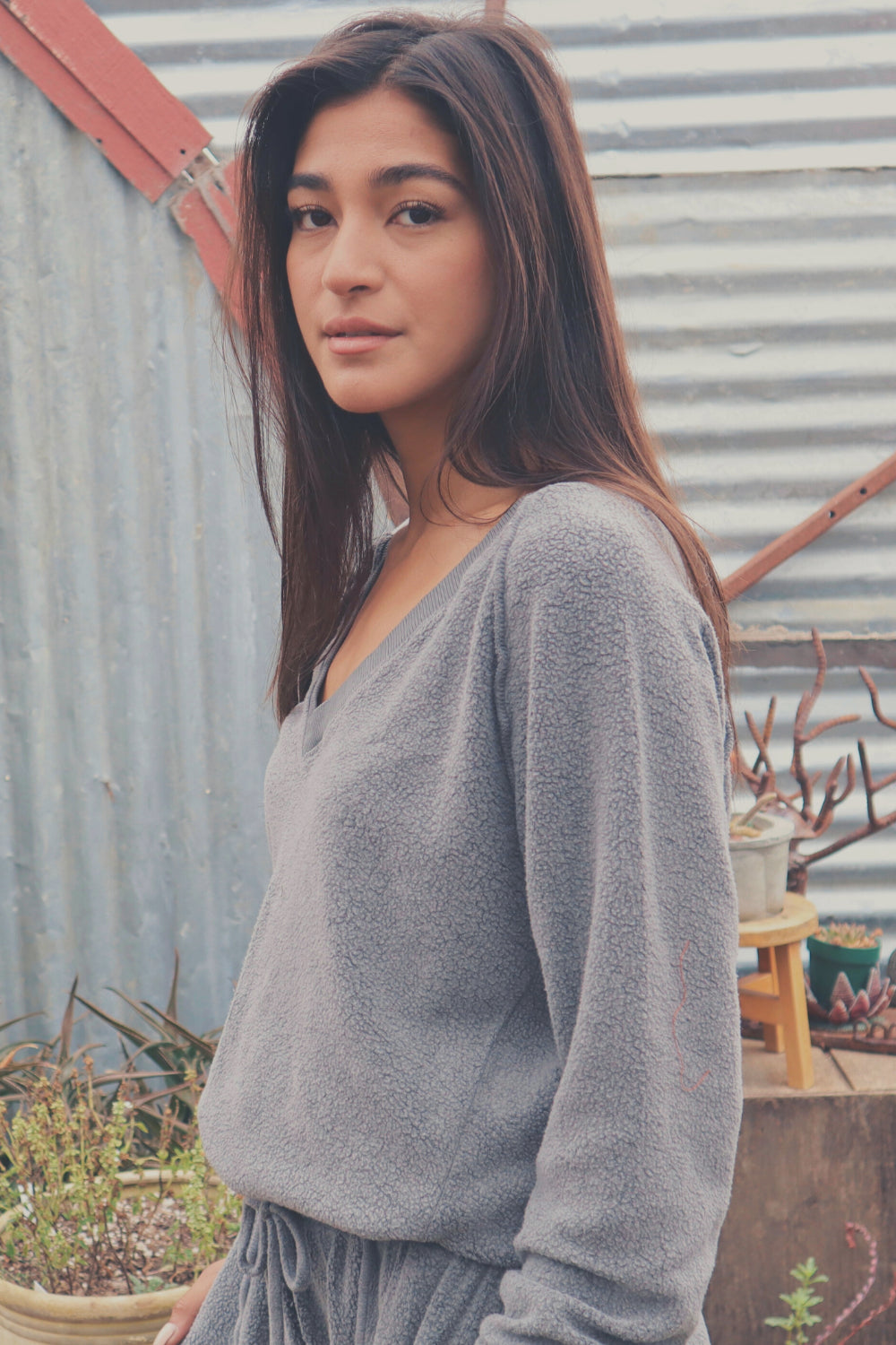 A cozy Gratitude V Pullover in sage green, showcasing its relaxed fit and plush fabric, perfect for casual wear.