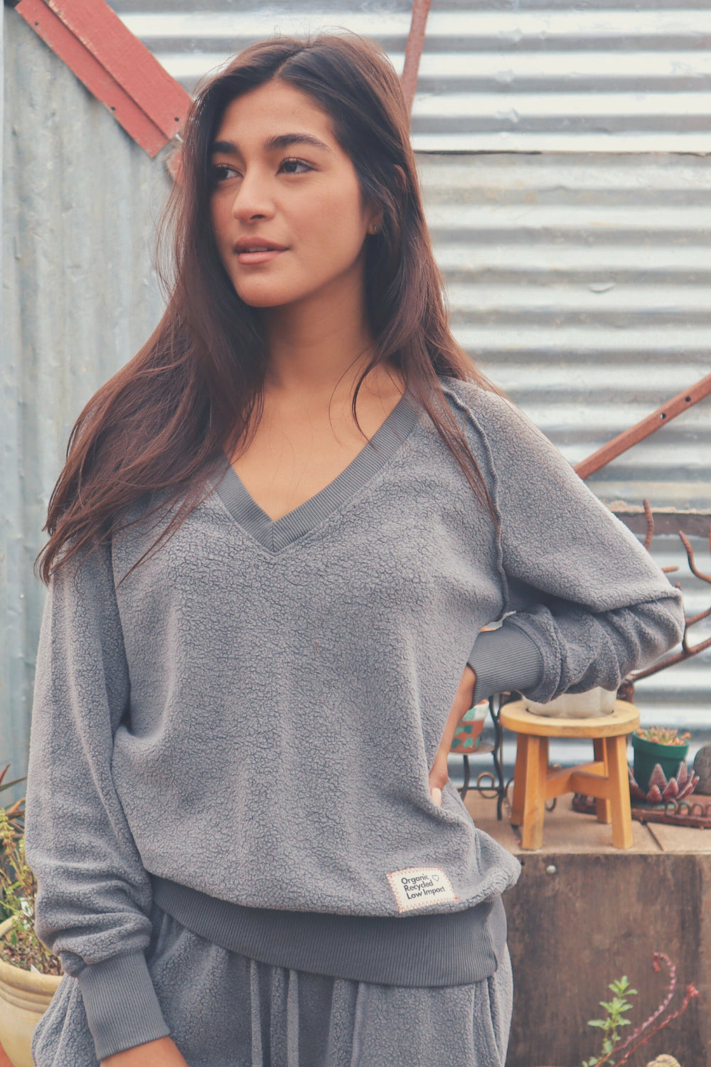 A cozy Gratitude V Pullover in sage green, showcasing its relaxed fit and plush fabric, perfect for casual wear.