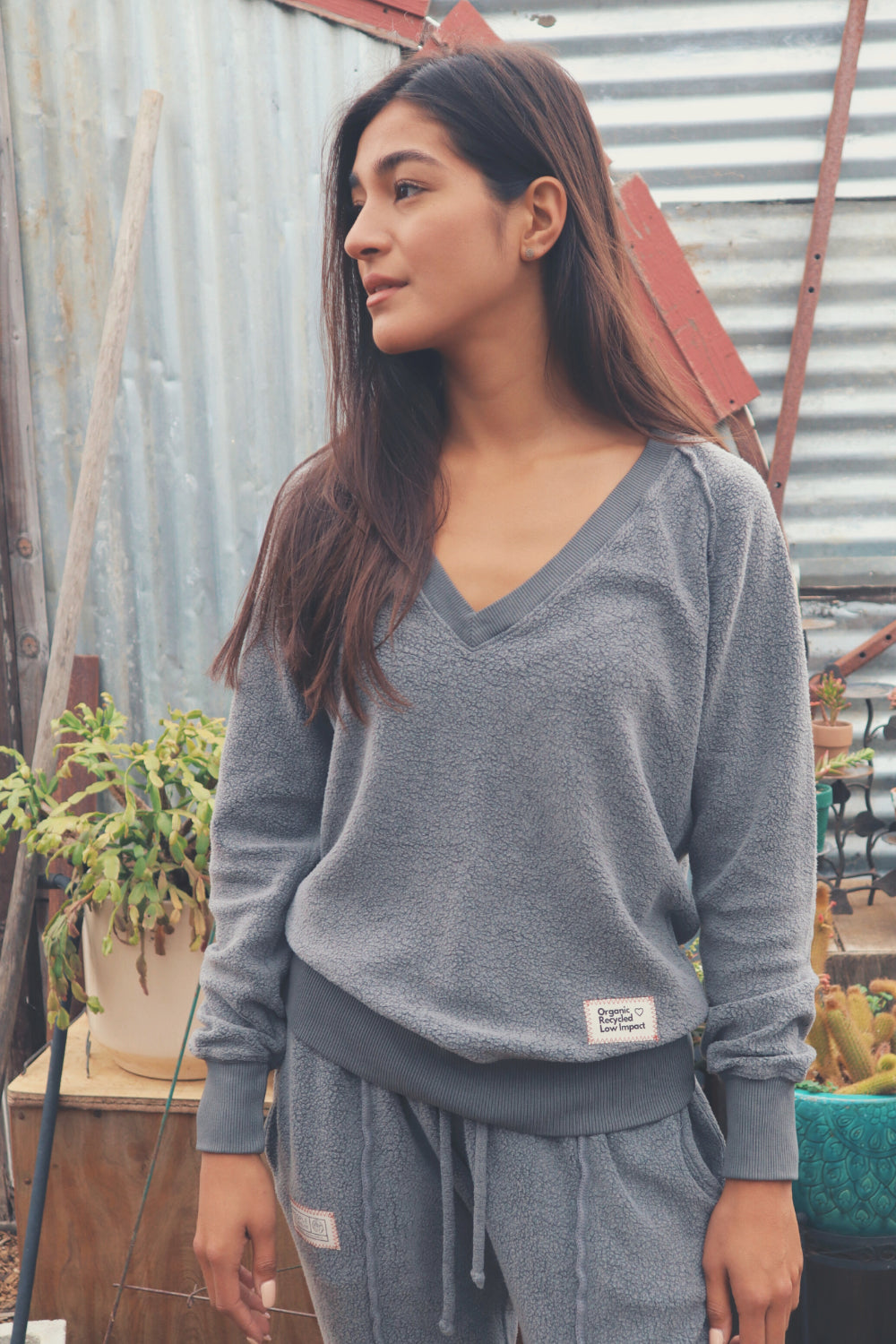 A cozy Gratitude V Pullover in sage green, showcasing its relaxed fit and plush fabric, perfect for casual wear.