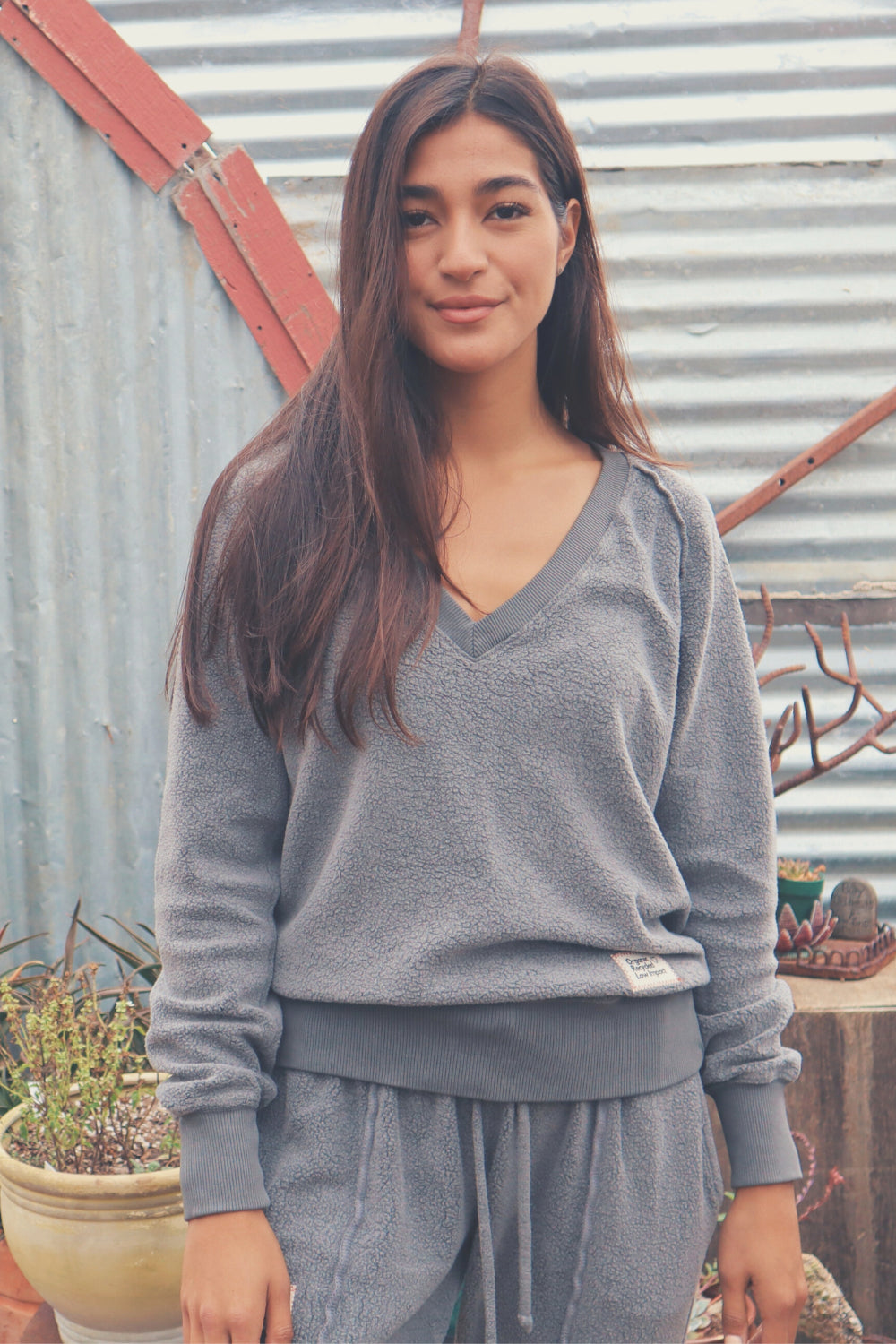 A cozy Gratitude V Pullover in sage green, showcasing its relaxed fit and plush fabric, perfect for casual wear.