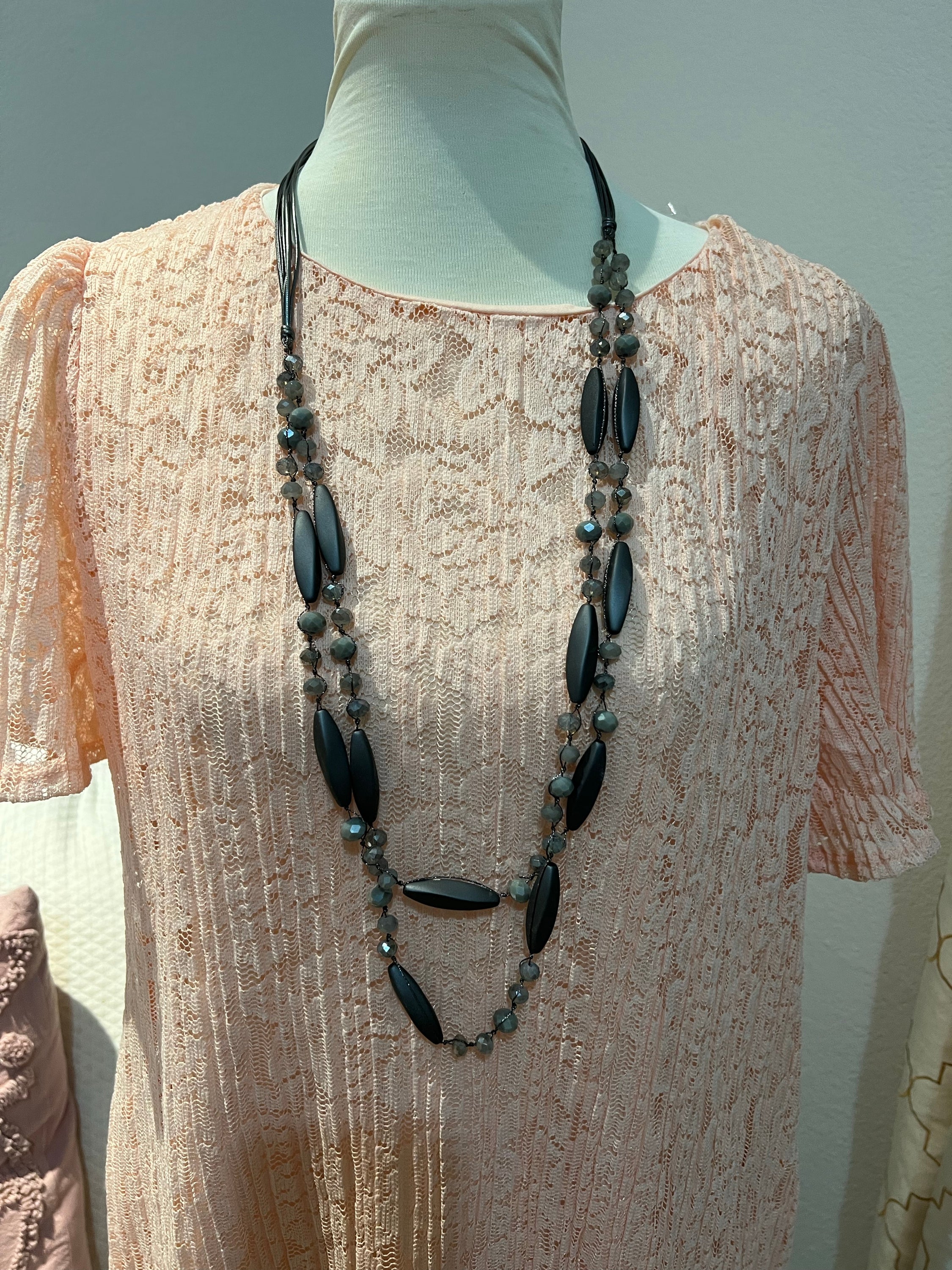 A stylish gray beaded long necklace featuring unique bead patterns, perfect for casual or formal wear.