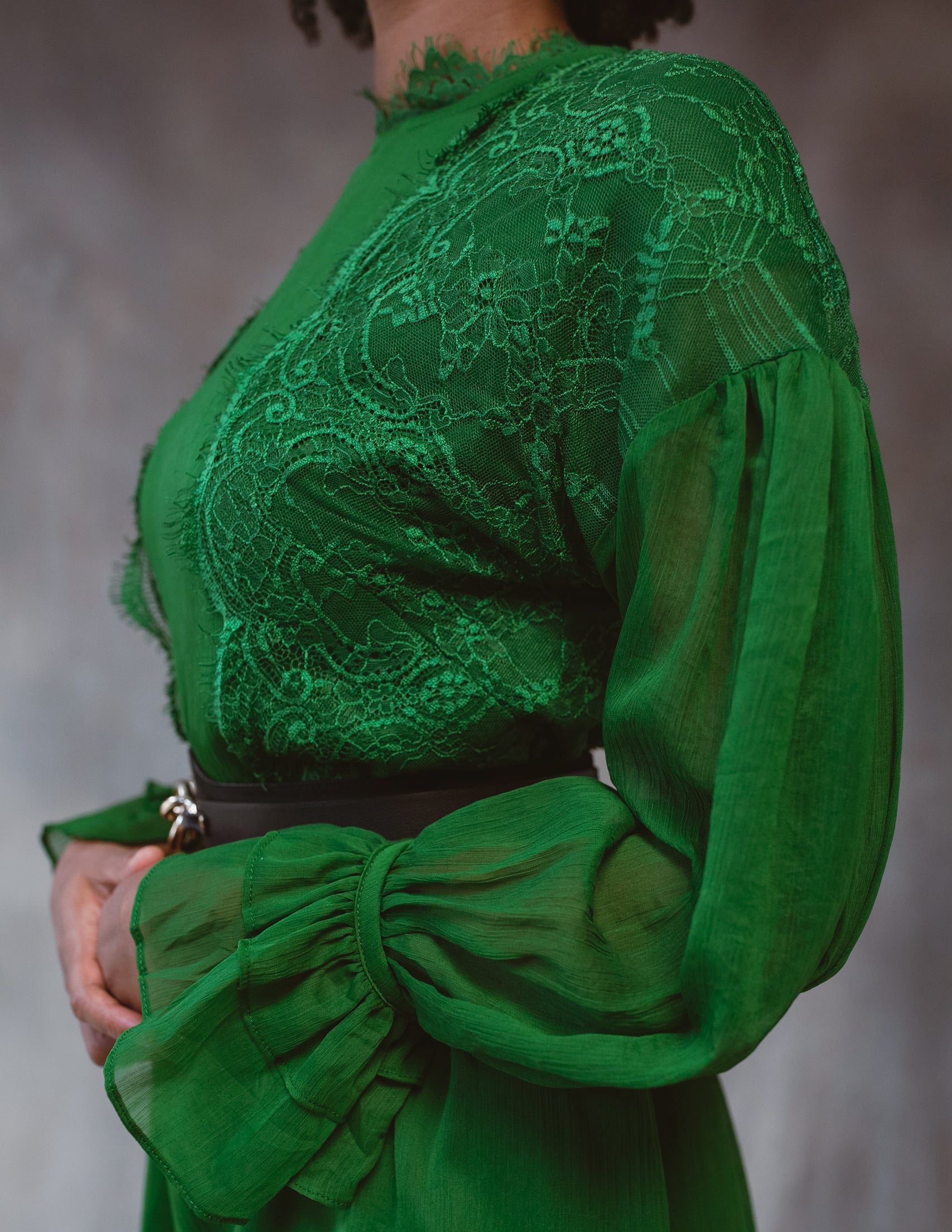 A beautiful green lace dress with long sleeves and a tiered design, perfect for elegant occasions.