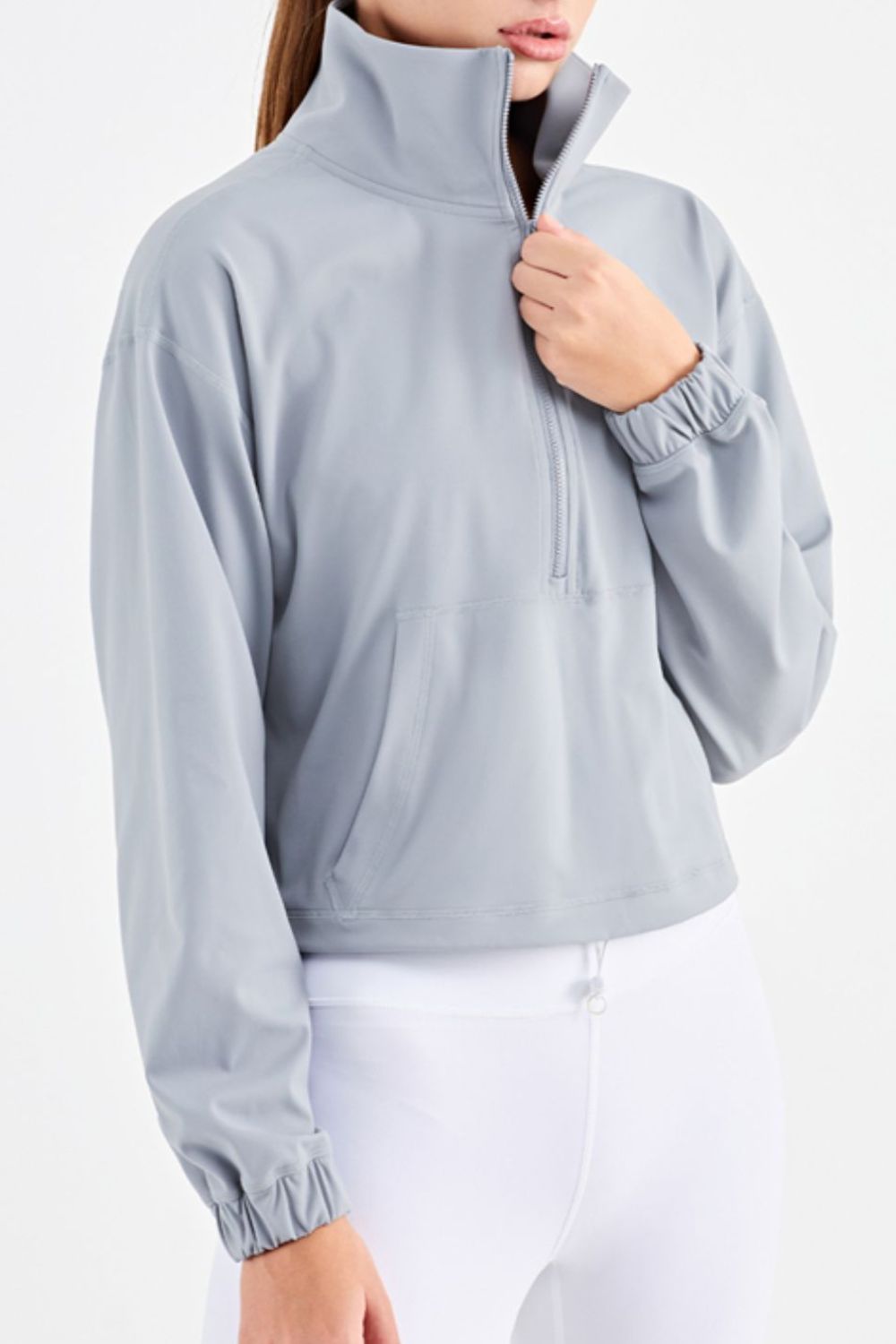 Half-Zip Dropped Shoulder Sports Top in a studio setting, showcasing its high neck and long sleeves, made from stretchy nylon and spandex.