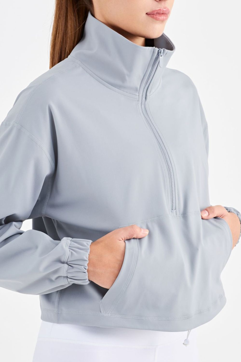 Half-Zip Dropped Shoulder Sports Top in a studio setting, showcasing its high neck and long sleeves, made from stretchy nylon and spandex.