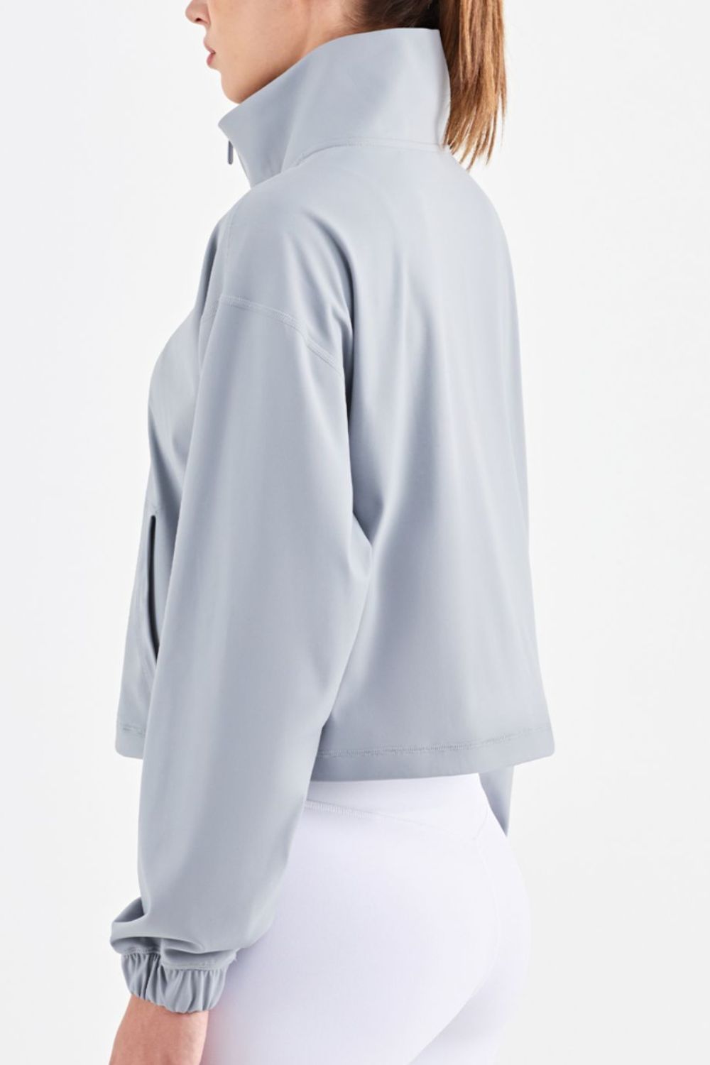 Half-Zip Dropped Shoulder Sports Top in a studio setting, showcasing its high neck and long sleeves, made from stretchy nylon and spandex.