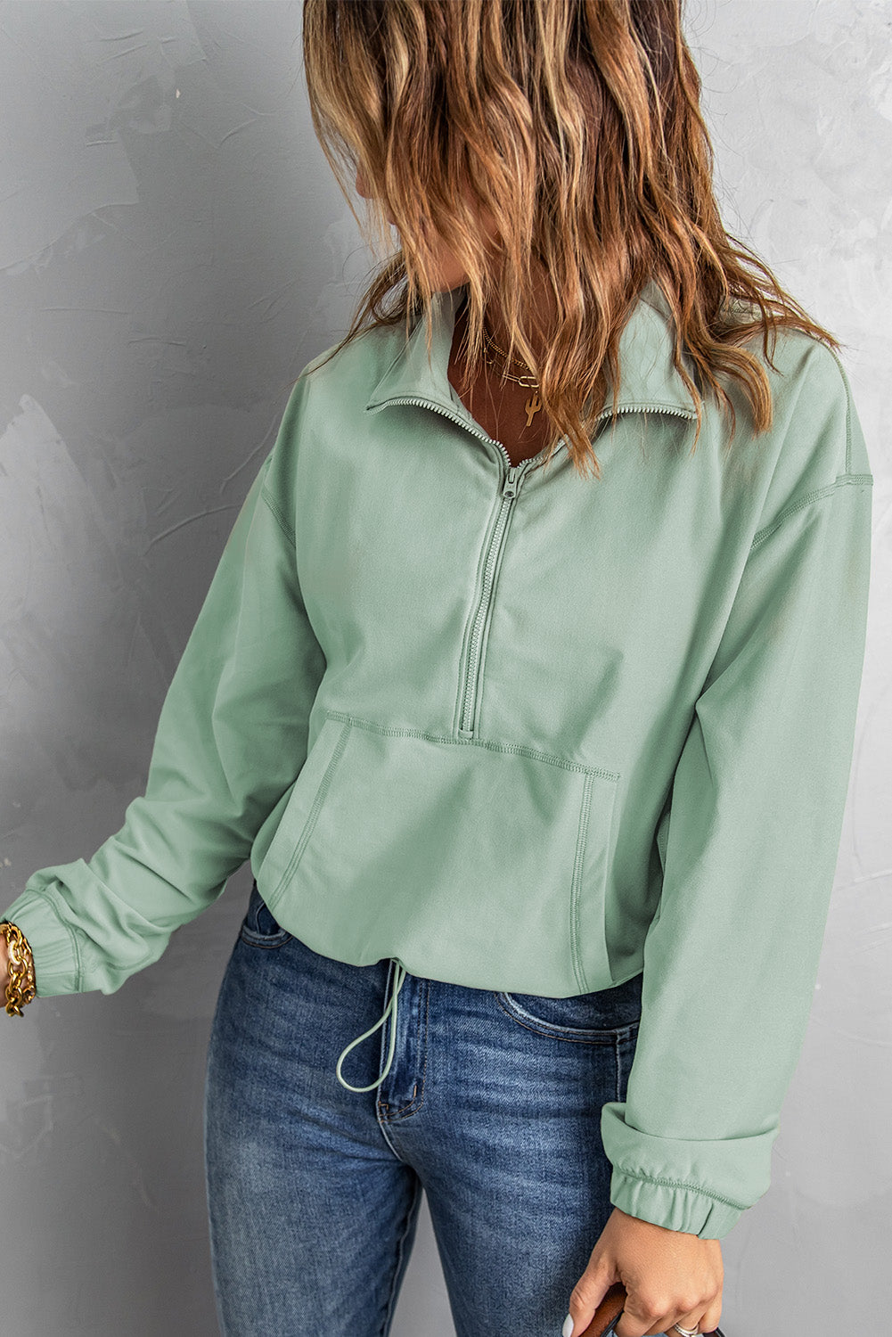 Half-Zip Exposed Seam Drawstring Hem Sweatshirt in solid color, featuring a collared neck, long sleeves, and convenient pockets.