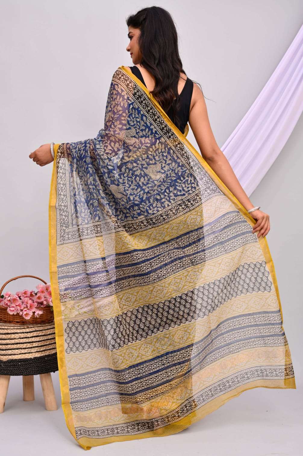 A beautifully draped hand block printed Kota Doria saree showcasing intricate patterns and vibrant colors, perfect for elegant occasions.