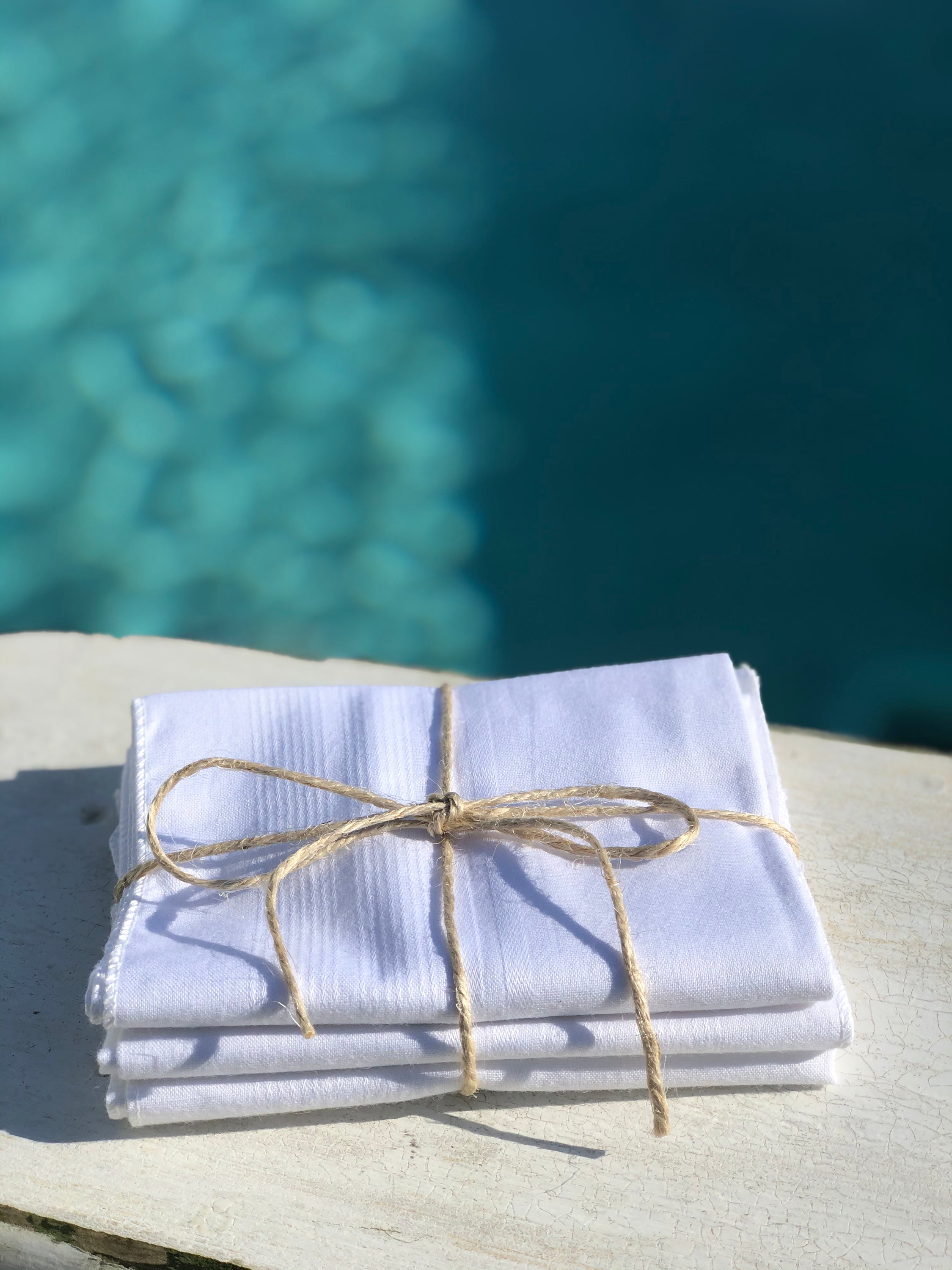 A set of three elegant handkerchiefs made from 100% cotton, showcasing their soft texture and eco-friendly design, perfect for stylish use.