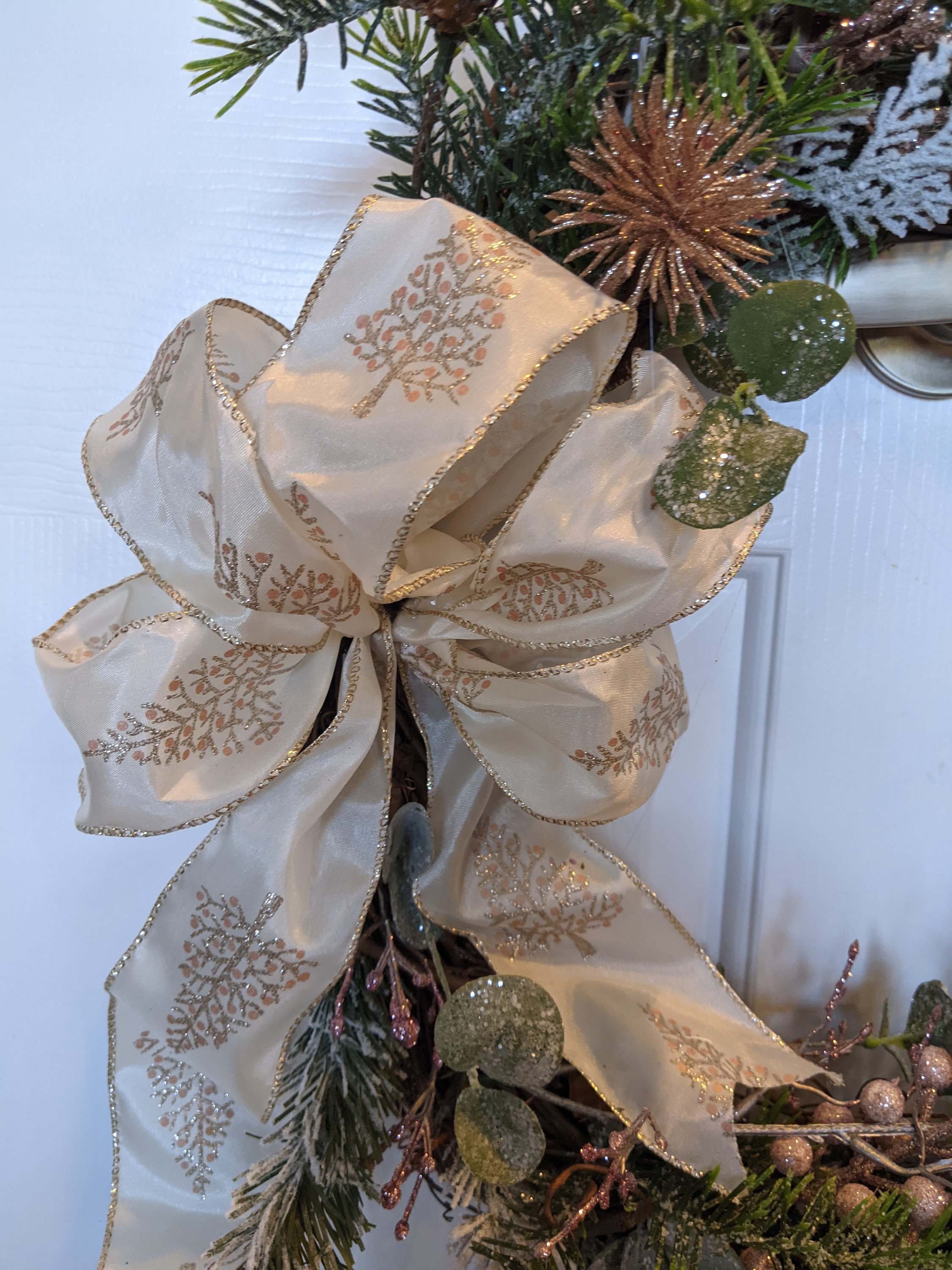 Handmade 18-inch grapevine wreath featuring sugary pink shades and winter greens, perfect for seasonal decor.