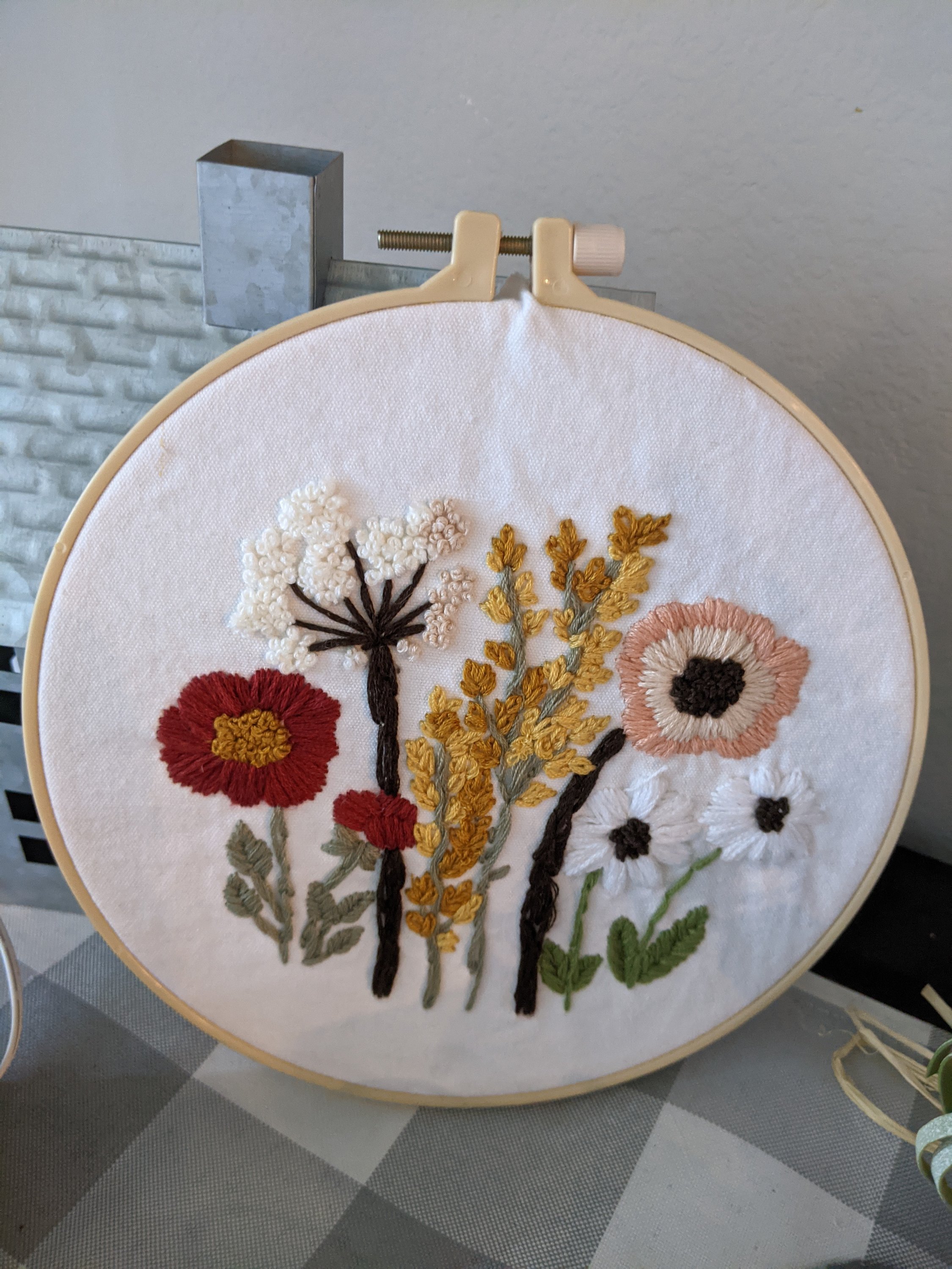 A beautifully crafted handmade embroidered hoop featuring intricate designs, perfect for hanging or displaying on a shelf.