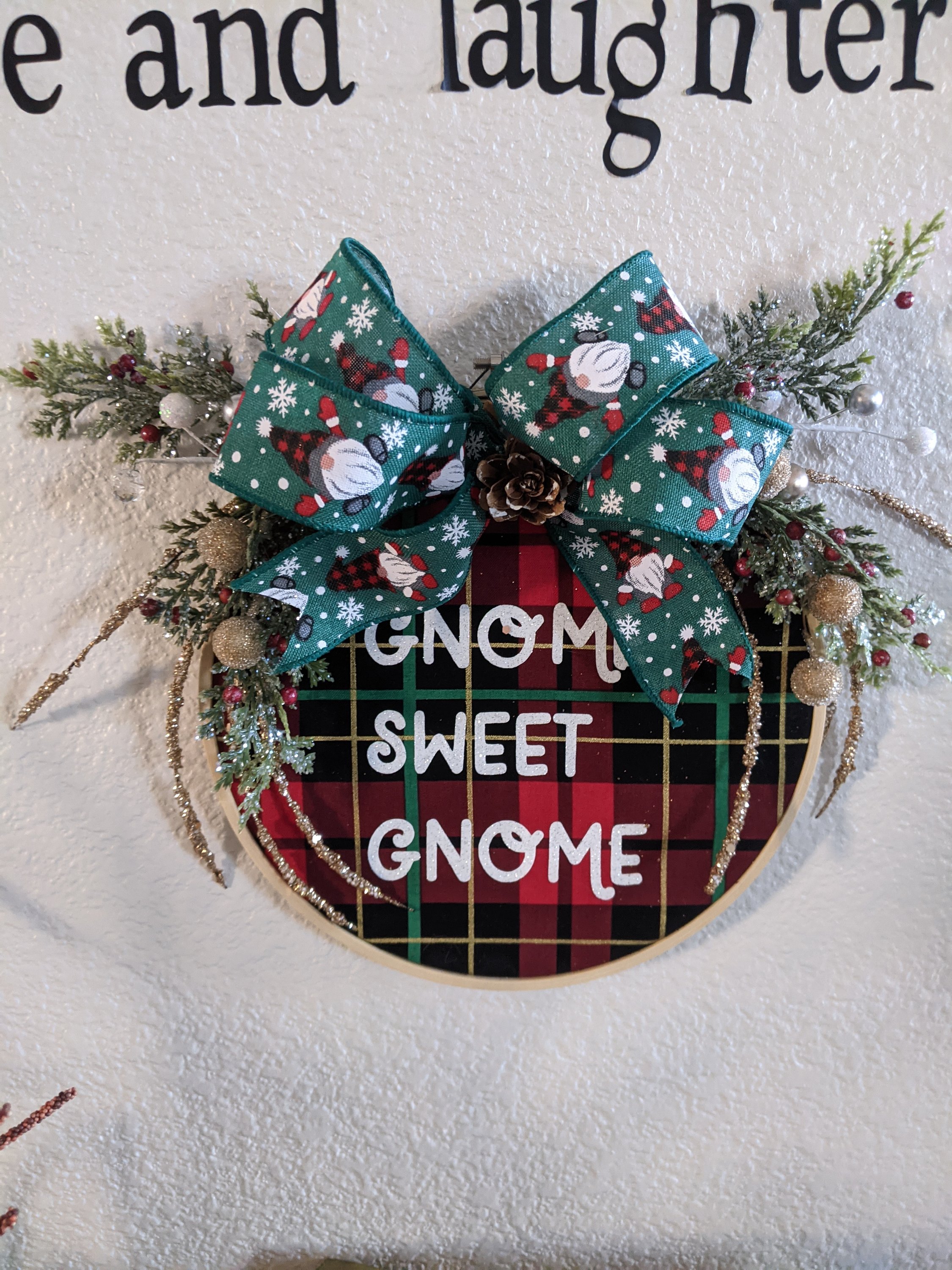 A charming 9 inch handmade gnome hoop featuring a buffalo check ribbon, perfect for winter decor.