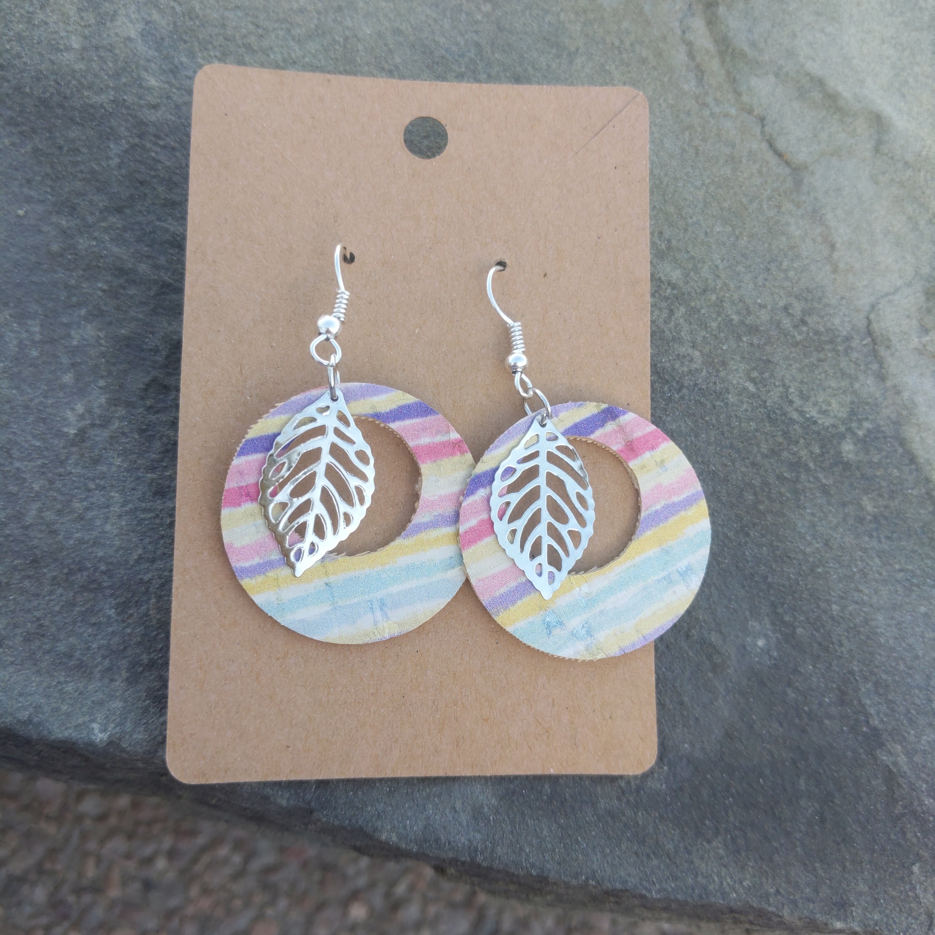 Handmade round cork rainbow earrings featuring vibrant colors and a silver filigree leaf accent, lightweight and stylish.