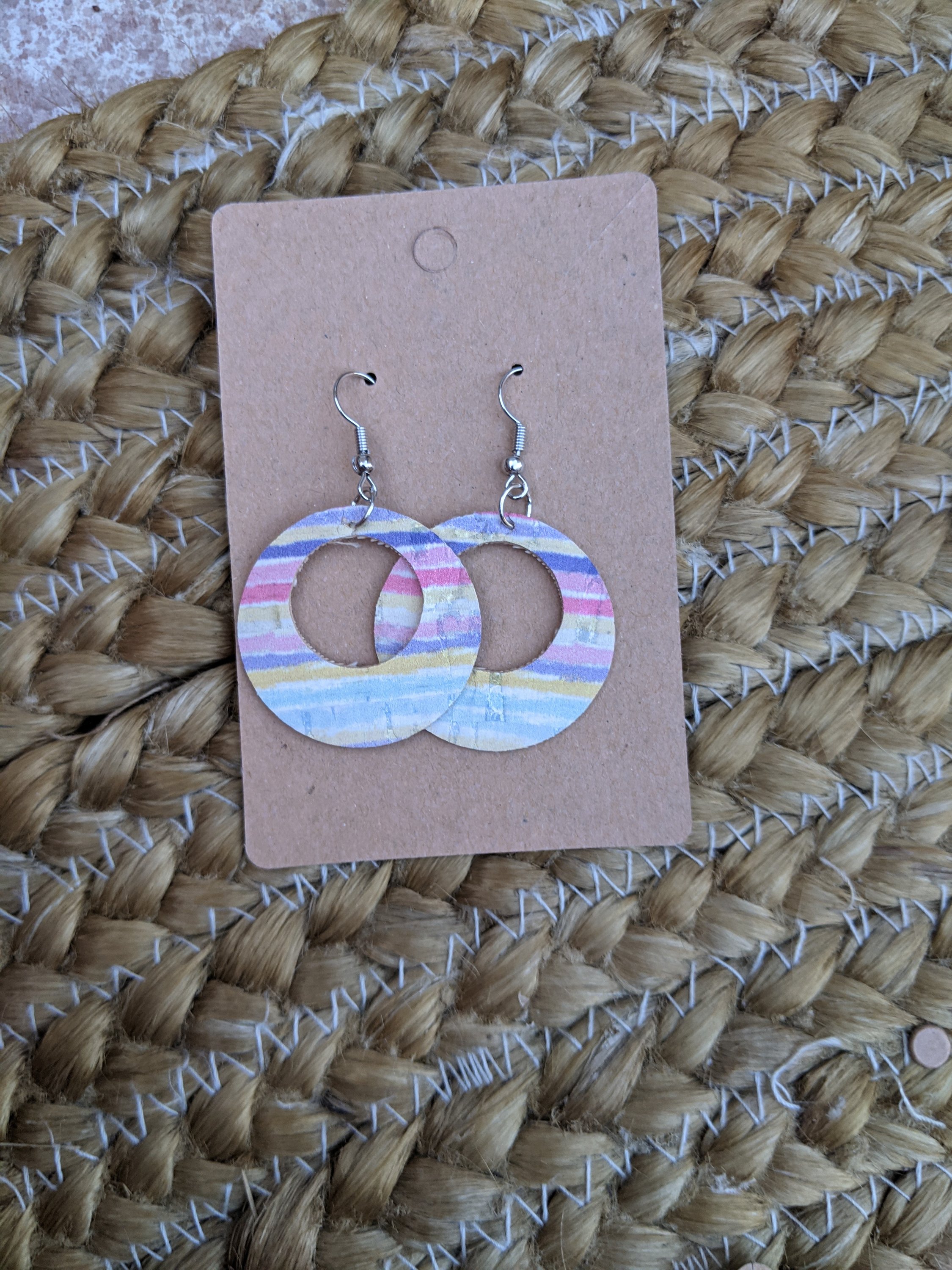 Handmade round cork rainbow earrings featuring vibrant colors and a silver filigree leaf accent, lightweight and stylish.