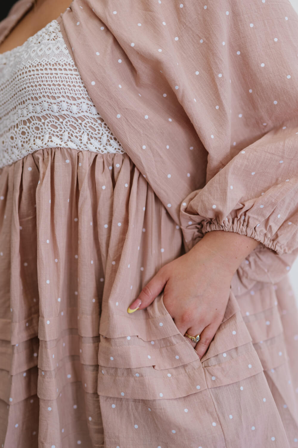 A feminine polka dot blouse featuring a lace yoke, balloon sleeves, and ruffle details, perfect for various occasions.