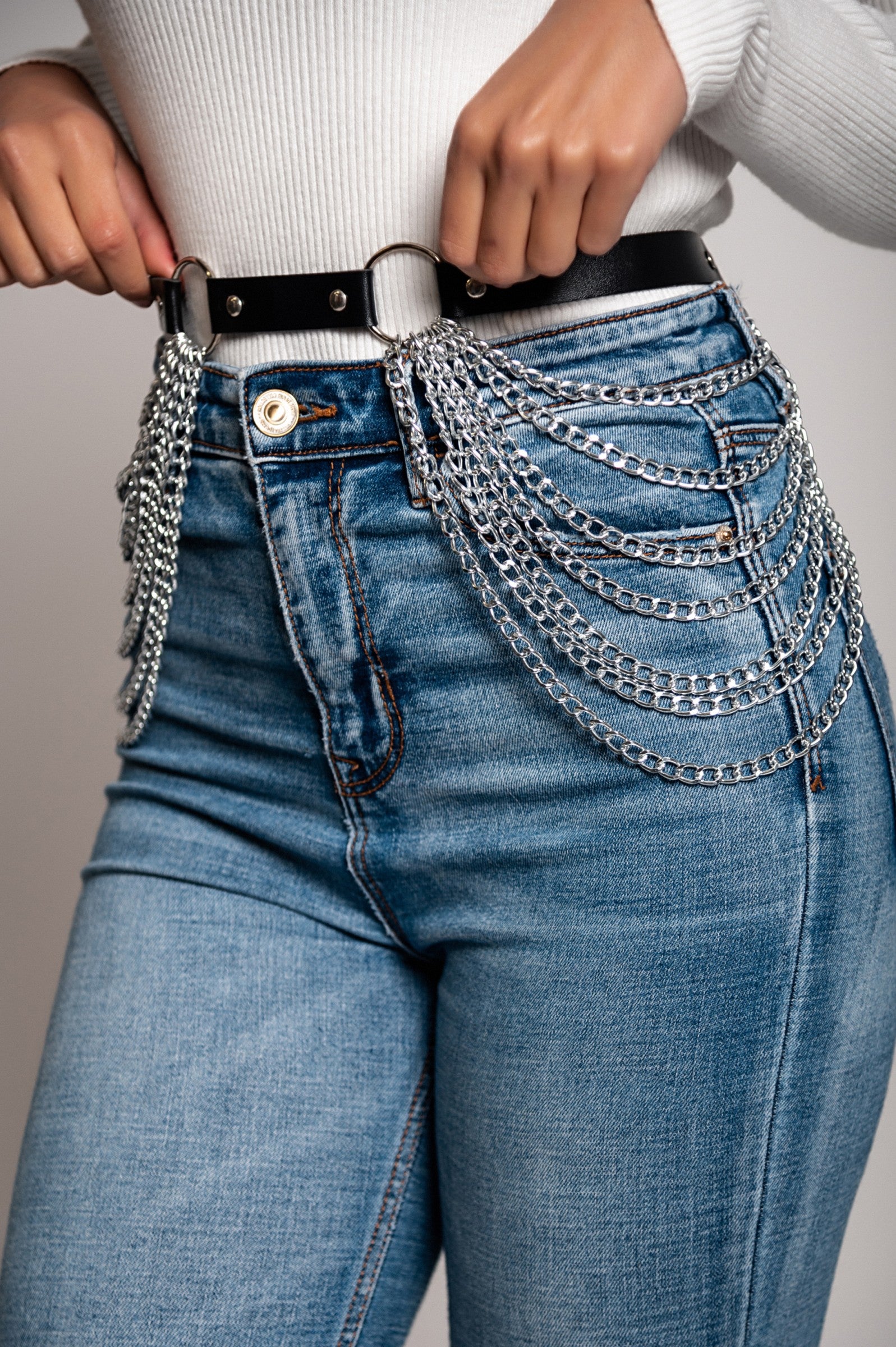 Black harness belt with decorative chains and metal buckle, showcasing high-quality imitation leather.