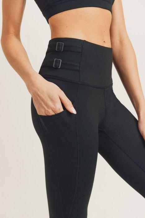 A pair of black highwaist leggings featuring adjustable harness straps on the sides, designed for comfort and style during workouts.