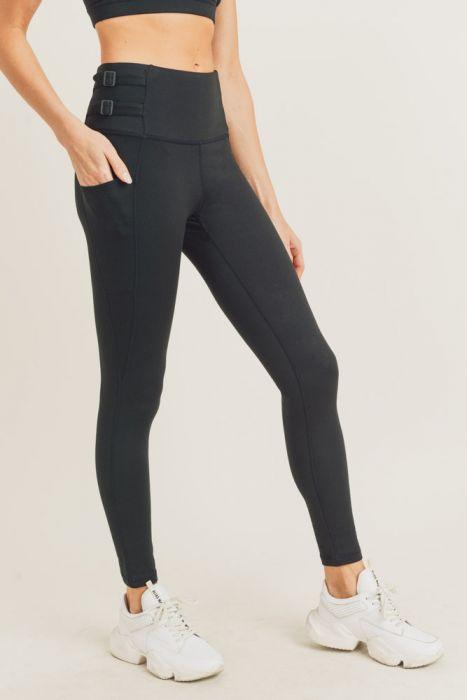 A pair of black highwaist leggings featuring adjustable harness straps on the sides, designed for comfort and style during workouts.