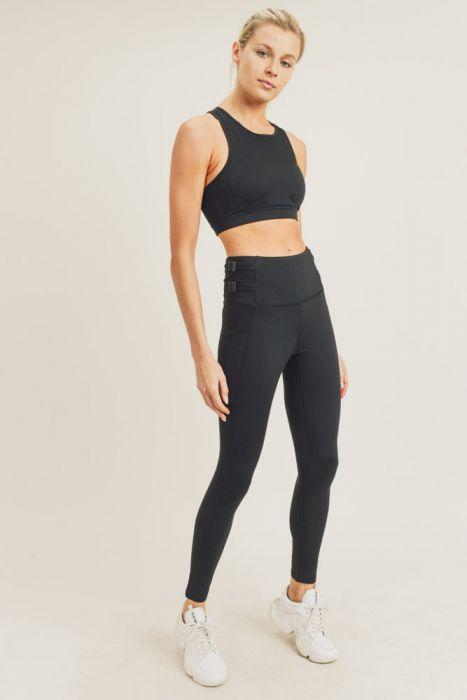 A pair of black highwaist leggings featuring adjustable harness straps on the sides, designed for comfort and style during workouts.