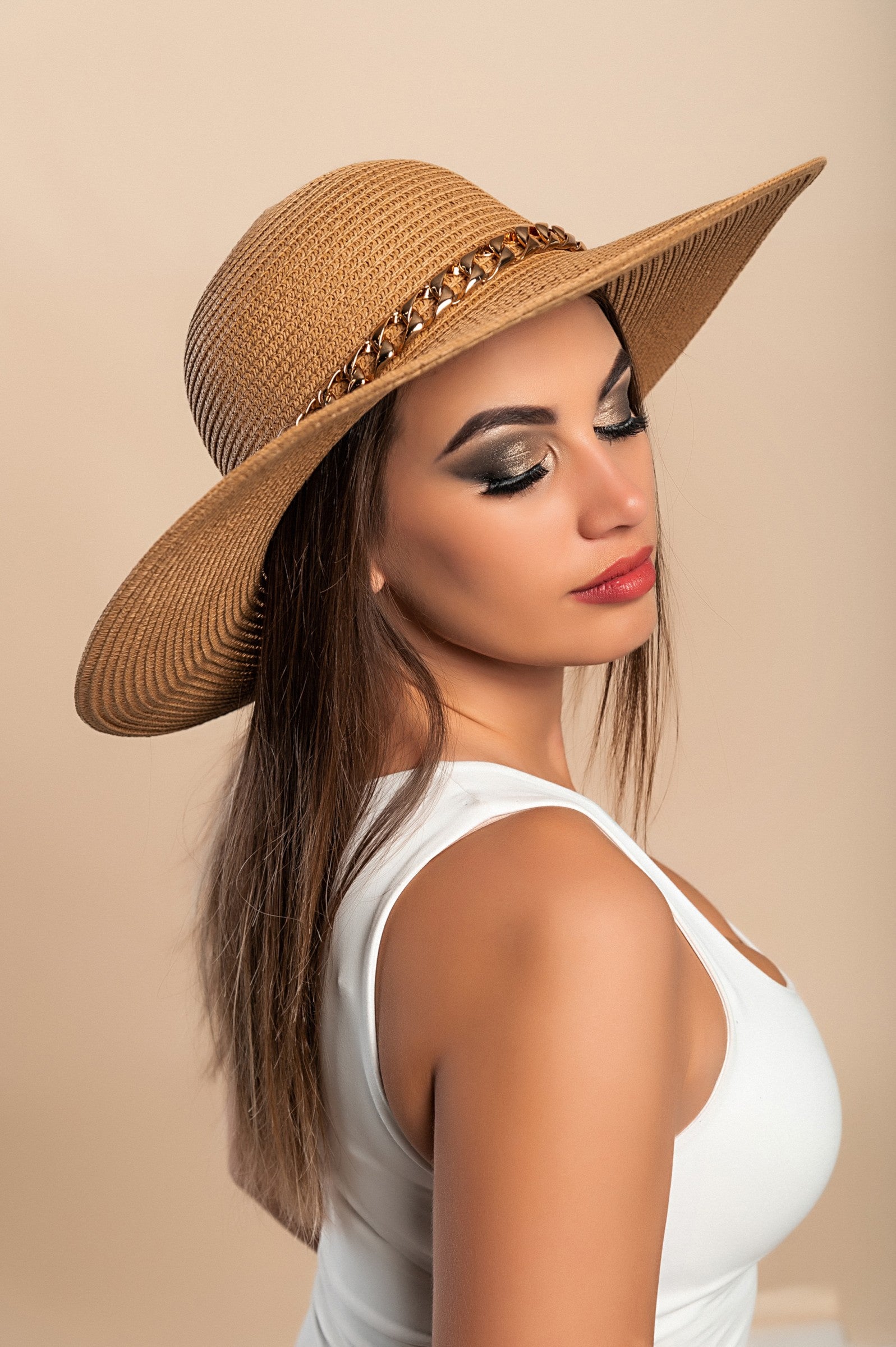 Stylish brown hat with a decorative bow and laces, featuring a round shape, perfect for various fashion combinations.