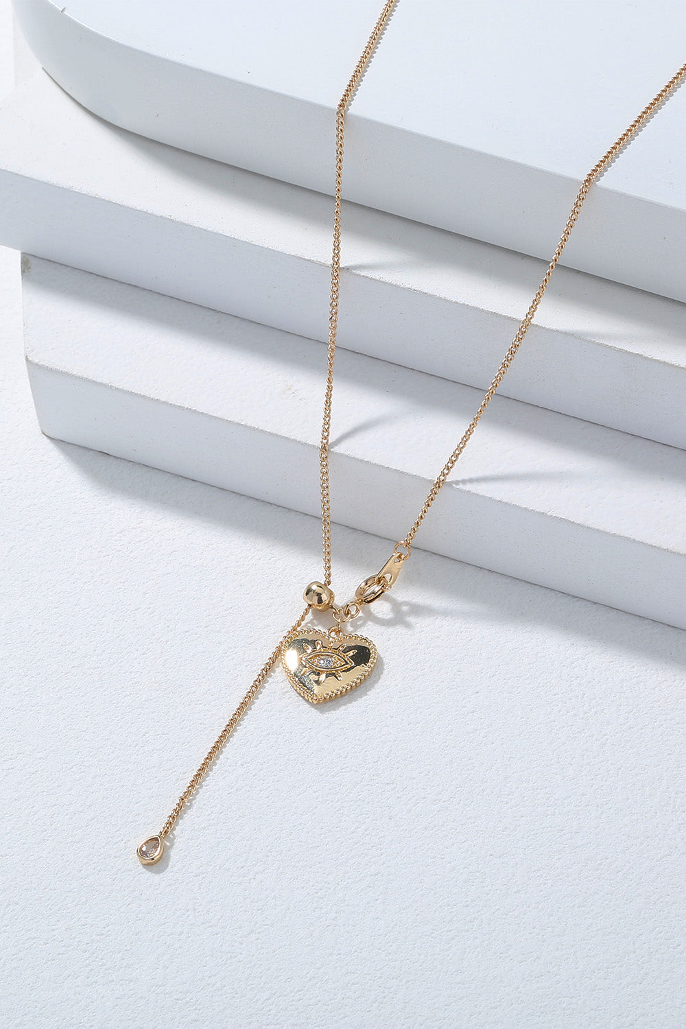 A beautiful Heart Pendant Drop Necklace featuring lustrous rhinestones on a brass chain, showcasing elegance and charm.