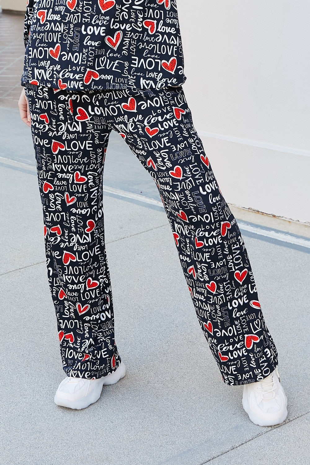 Heimish Full Size LOVE Heart Lounge Pants displayed outdoors, featuring a stylish printed pattern and comfortable fit.