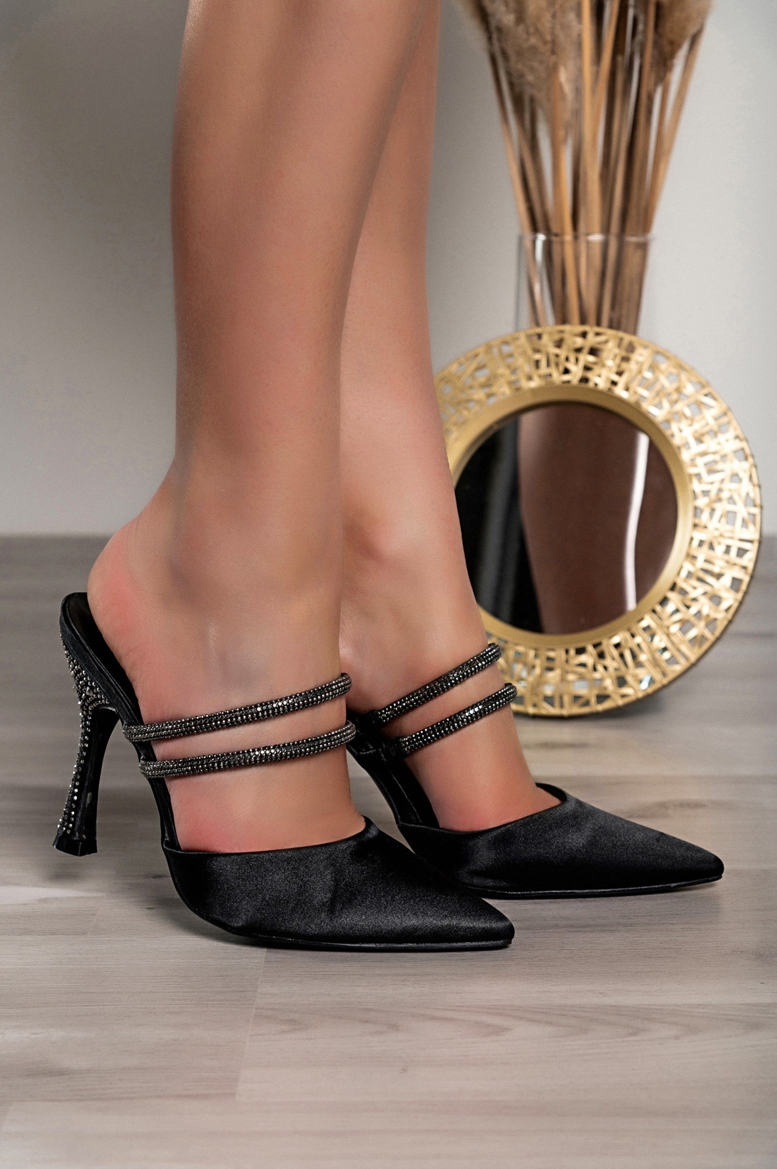 Elegant black heeled shoes with rhinestone straps and pointed toe design, showcasing a fine thin heel.