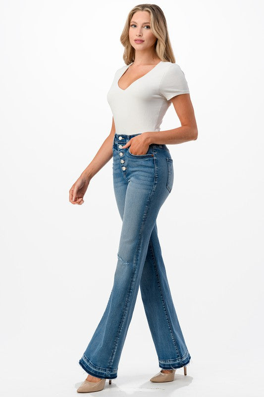 High rise bootcut jeans featuring distress and fray hem, styled on a model.