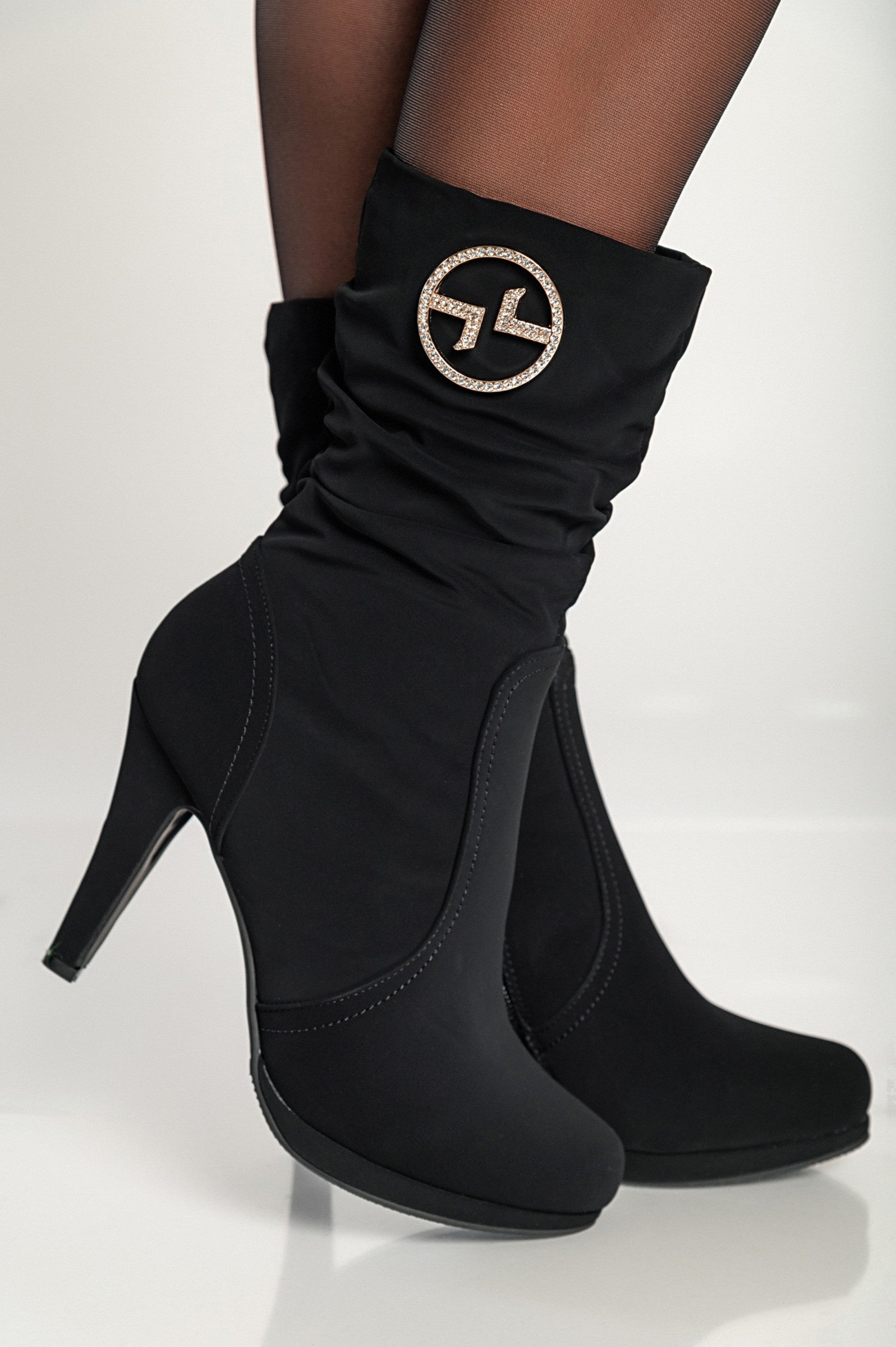 Elegant black high-heeled ankle boots with pointed toe and inside zipper closure, featuring decorative details.