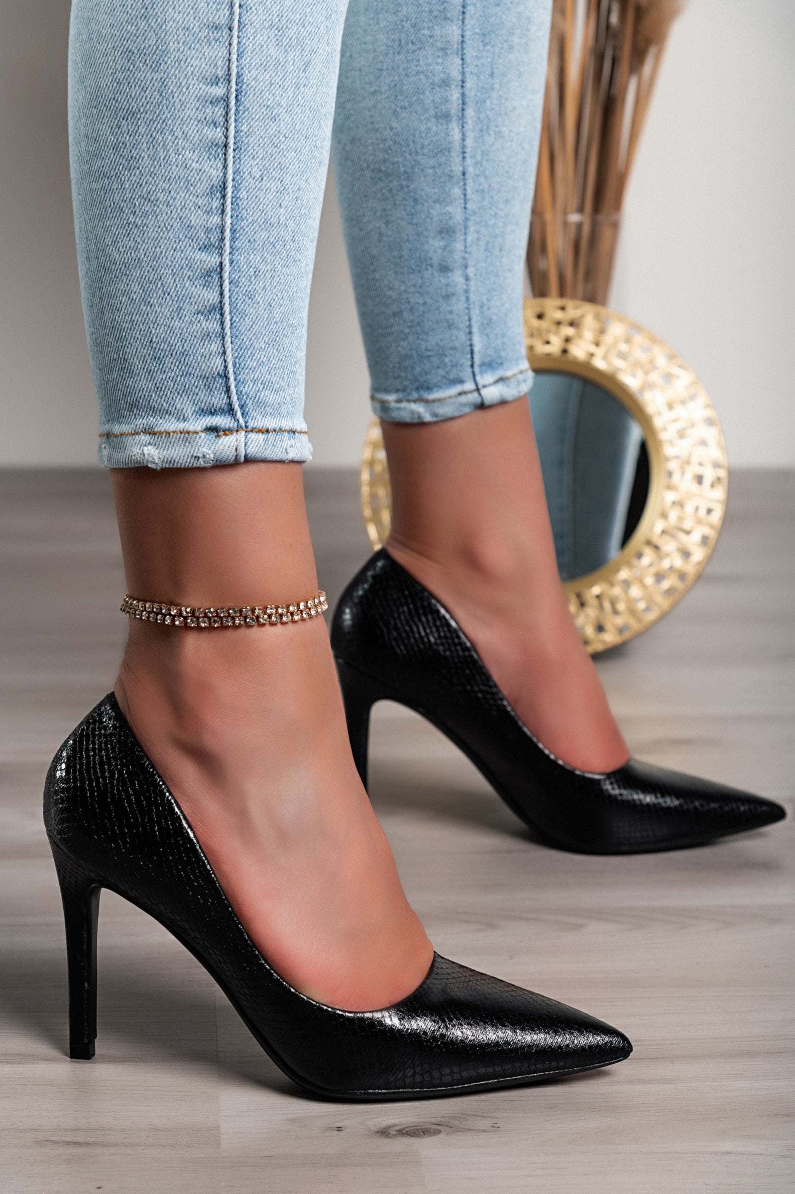 Elegant black high-heeled shoes with a stylish snakeskin print, featuring a pointed toe and fine thin heel.