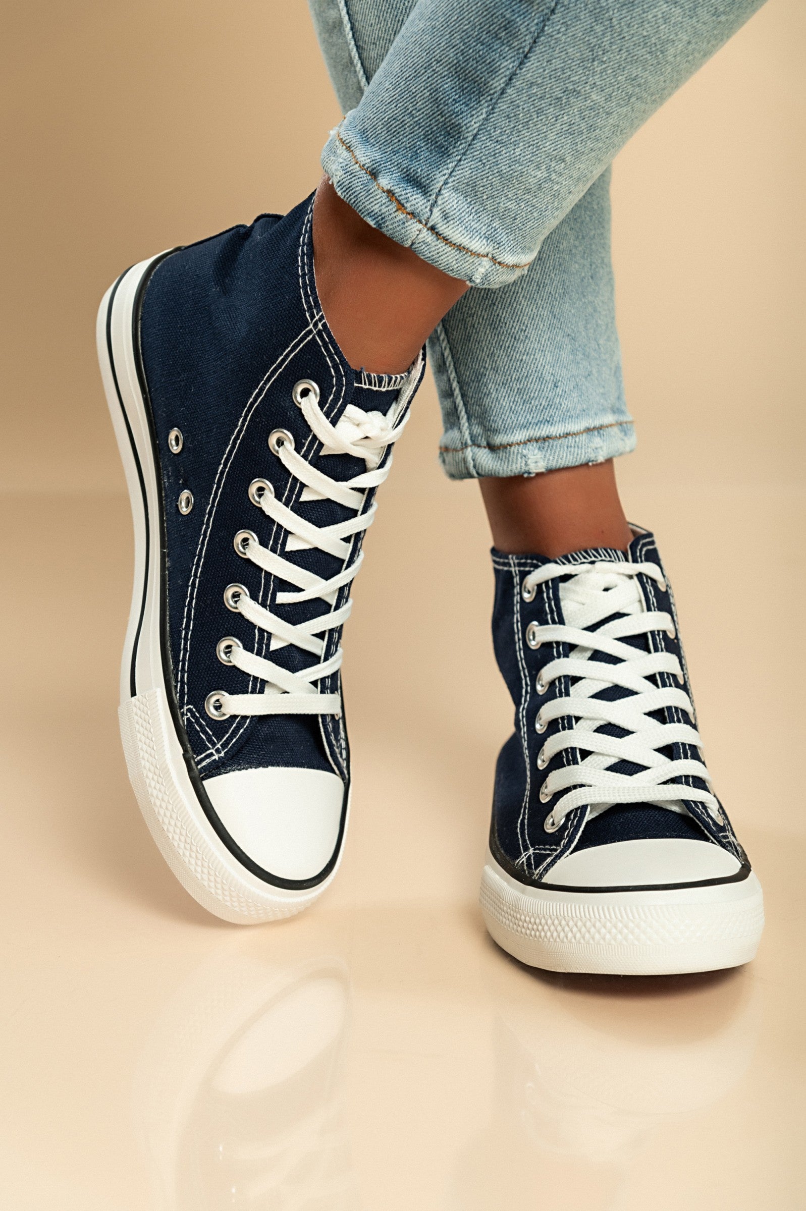 A pair of dark blue high-top canvas sneakers with a round plastic toe and lace-up fastening, showcasing a stylish and comfortable design.