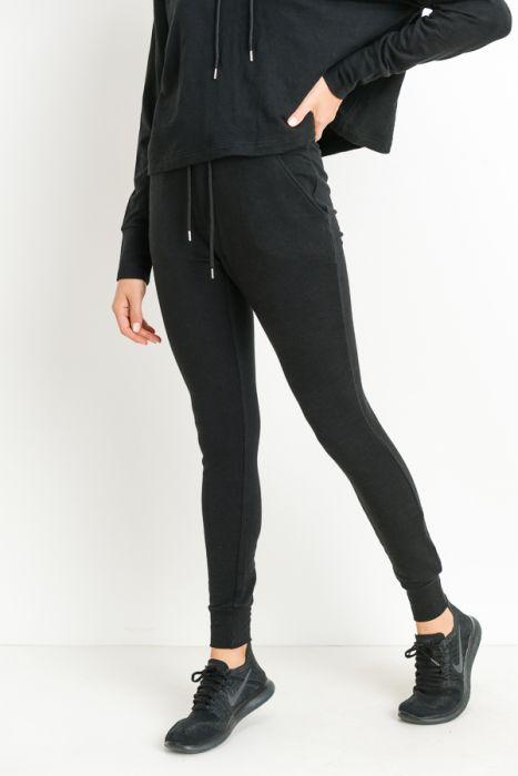 Highwaist slim-fit cuffed joggers in a stylish design, featuring a drawstring closure and side pockets for convenience.