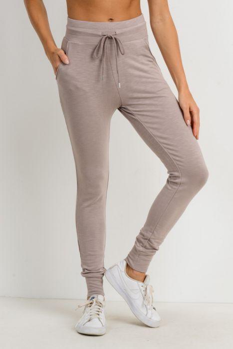 Highwaist slim-fit cuffed joggers in a stylish design, featuring a drawstring closure and side pockets for convenience.