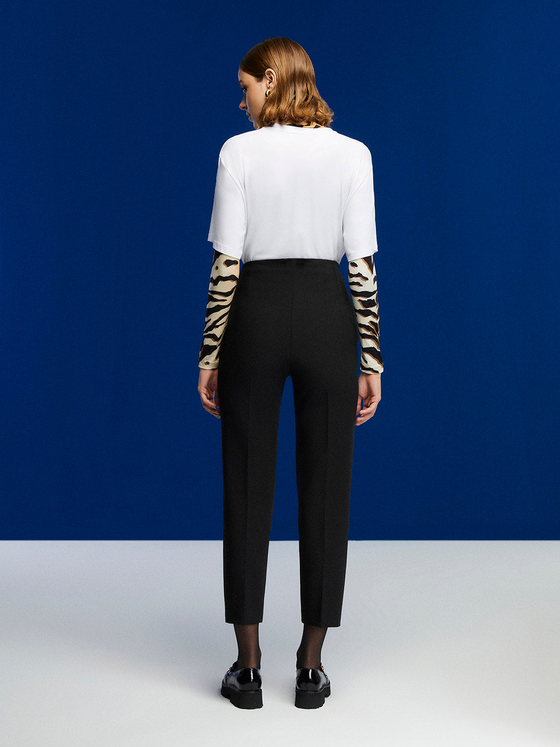 A pair of stylish high-waisted pants featuring side welt pockets and elegant pleat details, perfect for any occasion.