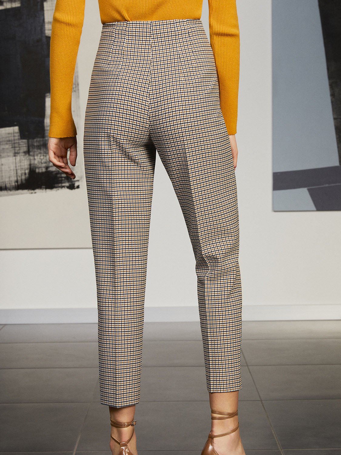 High-waisted plaid pants with tapered ankle-length fit and hidden side zip closure, showcasing a stylish design suitable for various occasions.