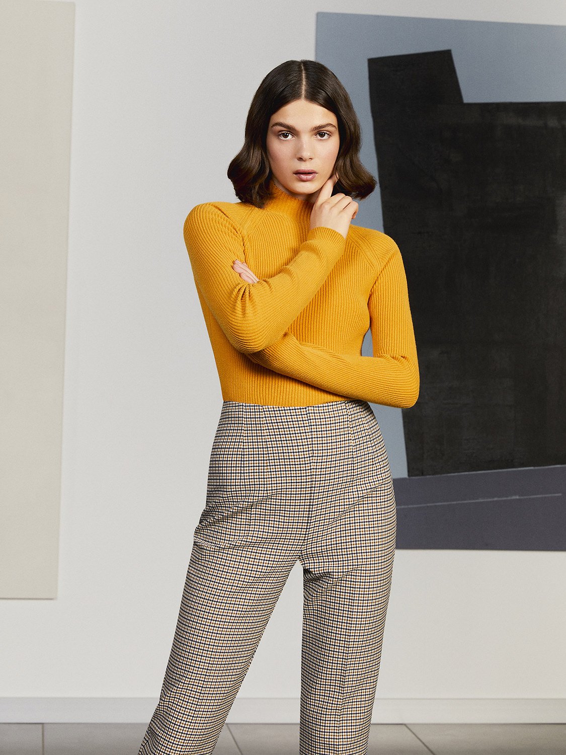 High-waisted plaid pants with tapered ankle-length fit and hidden side zip closure, showcasing a stylish design suitable for various occasions.