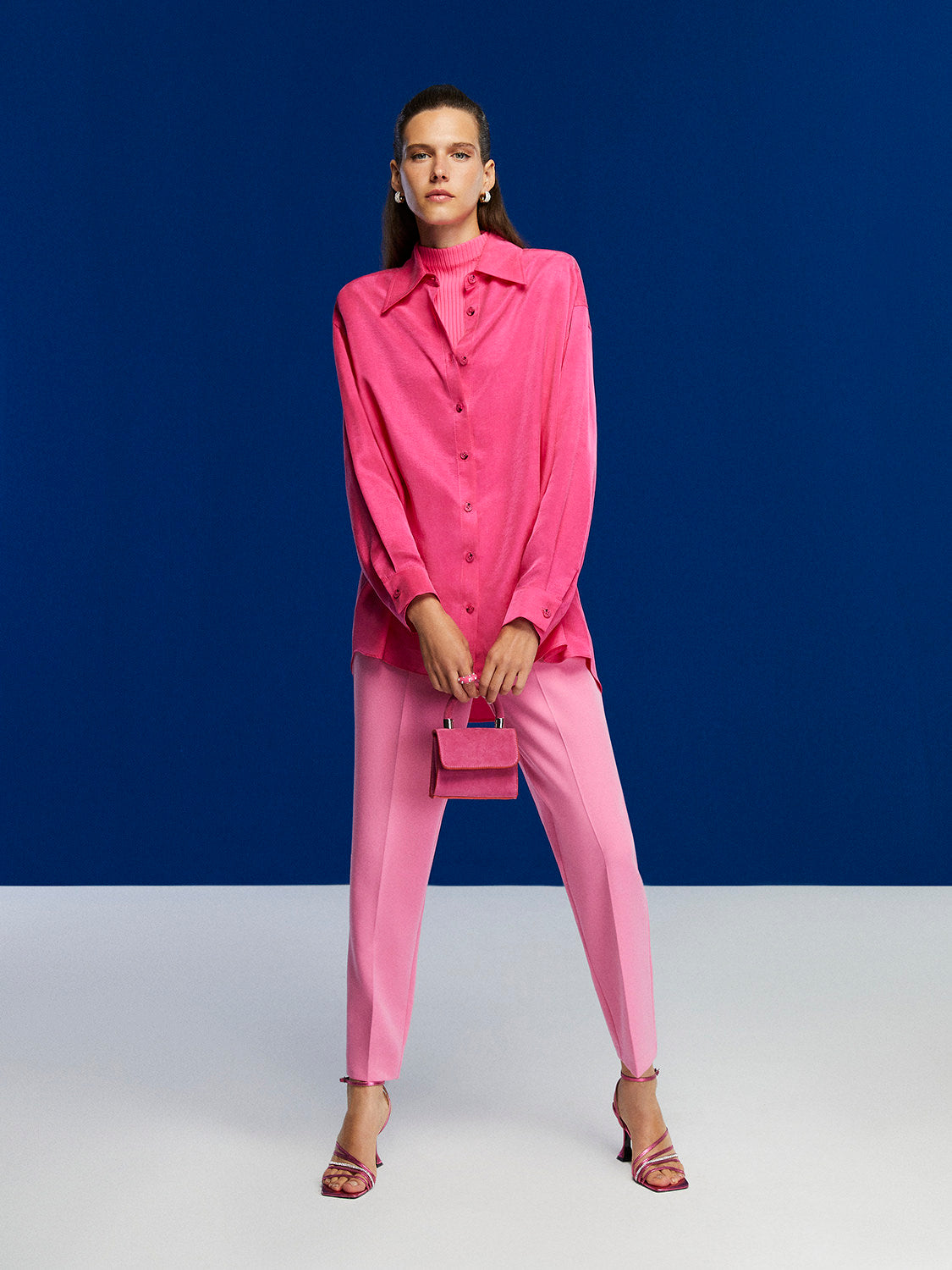 High-waisted tapered pants in vibrant orange, pink, and blue colors with side pockets and a modern fit.