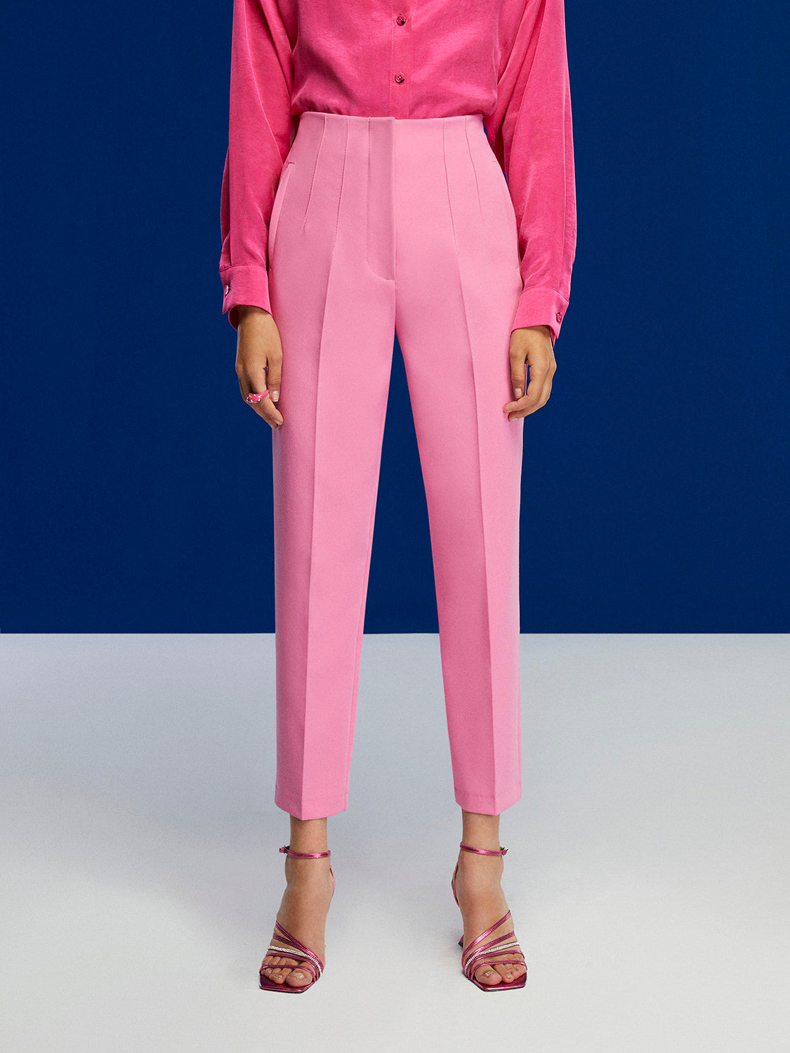 High-waisted tapered pants in vibrant orange, pink, and blue colors with side pockets and a modern fit.