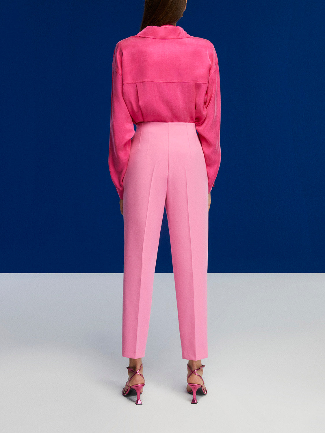 High-waisted tapered pants in vibrant orange, pink, and blue colors with side pockets and a modern fit.