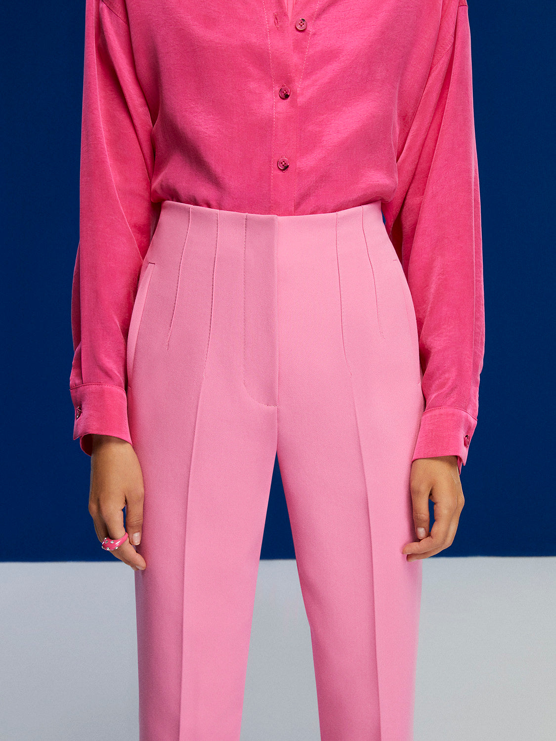 High-waisted tapered pants in vibrant orange, pink, and blue colors with side pockets and a modern fit.