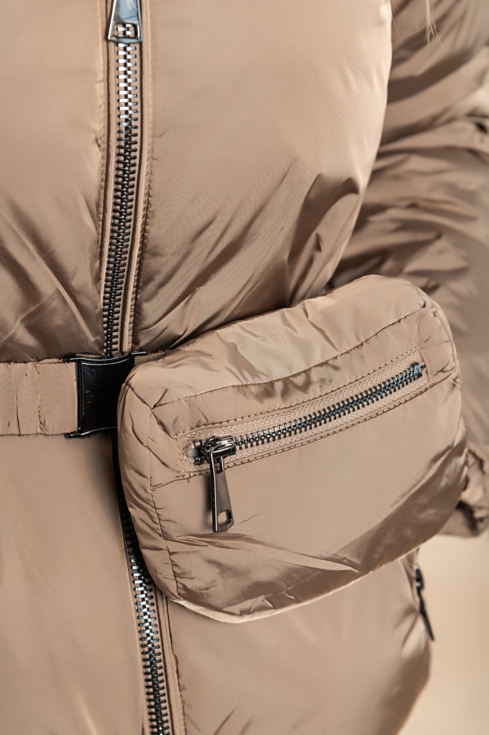 Beige hooded jacket with warm padding, high collar, and side zipper pockets, featuring an elastic belt with a bag.