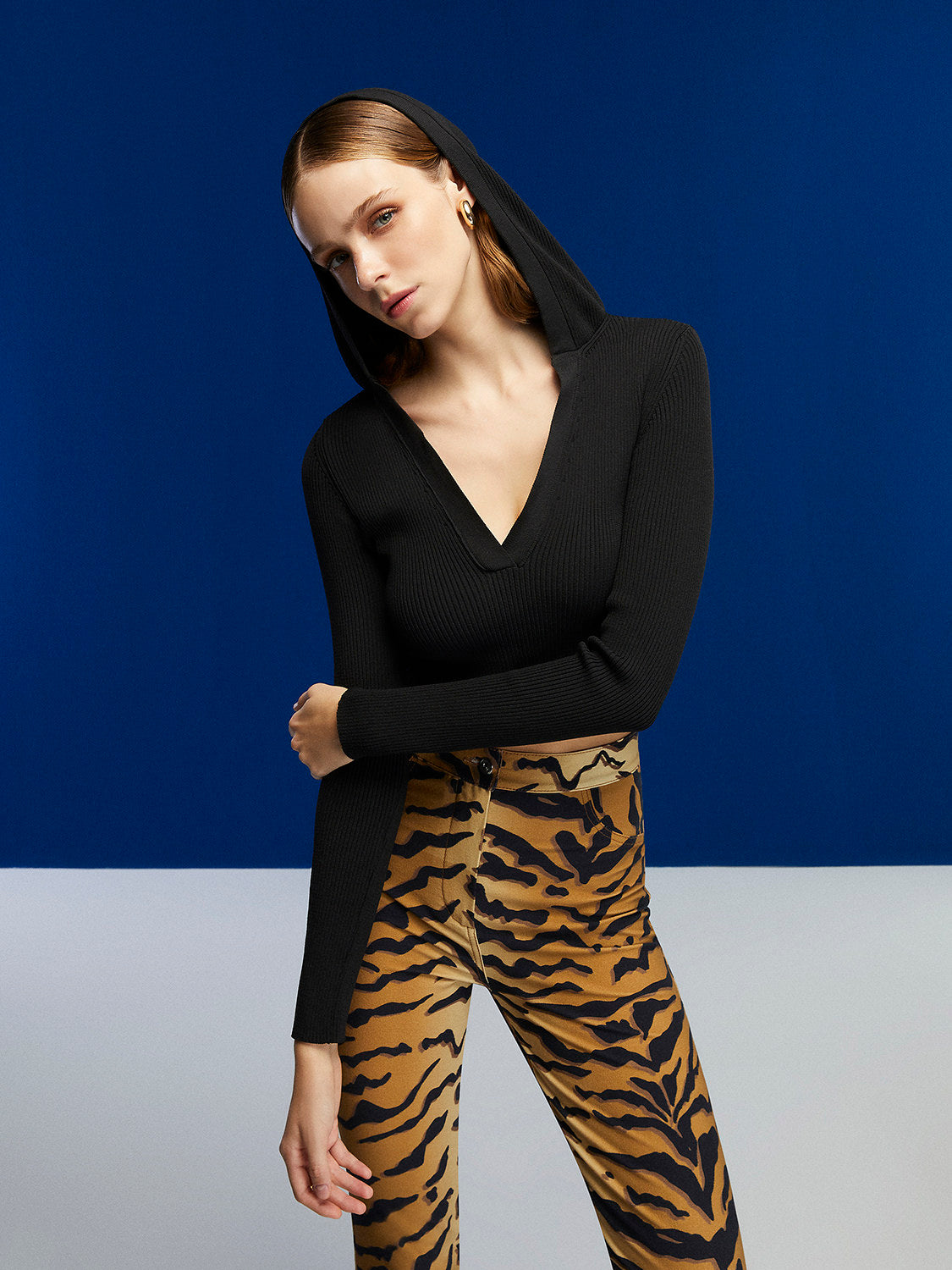 A stylish Hooded Knit Crop Top featuring a V-neck and long sleeves, designed in a trendy leopard print pattern.