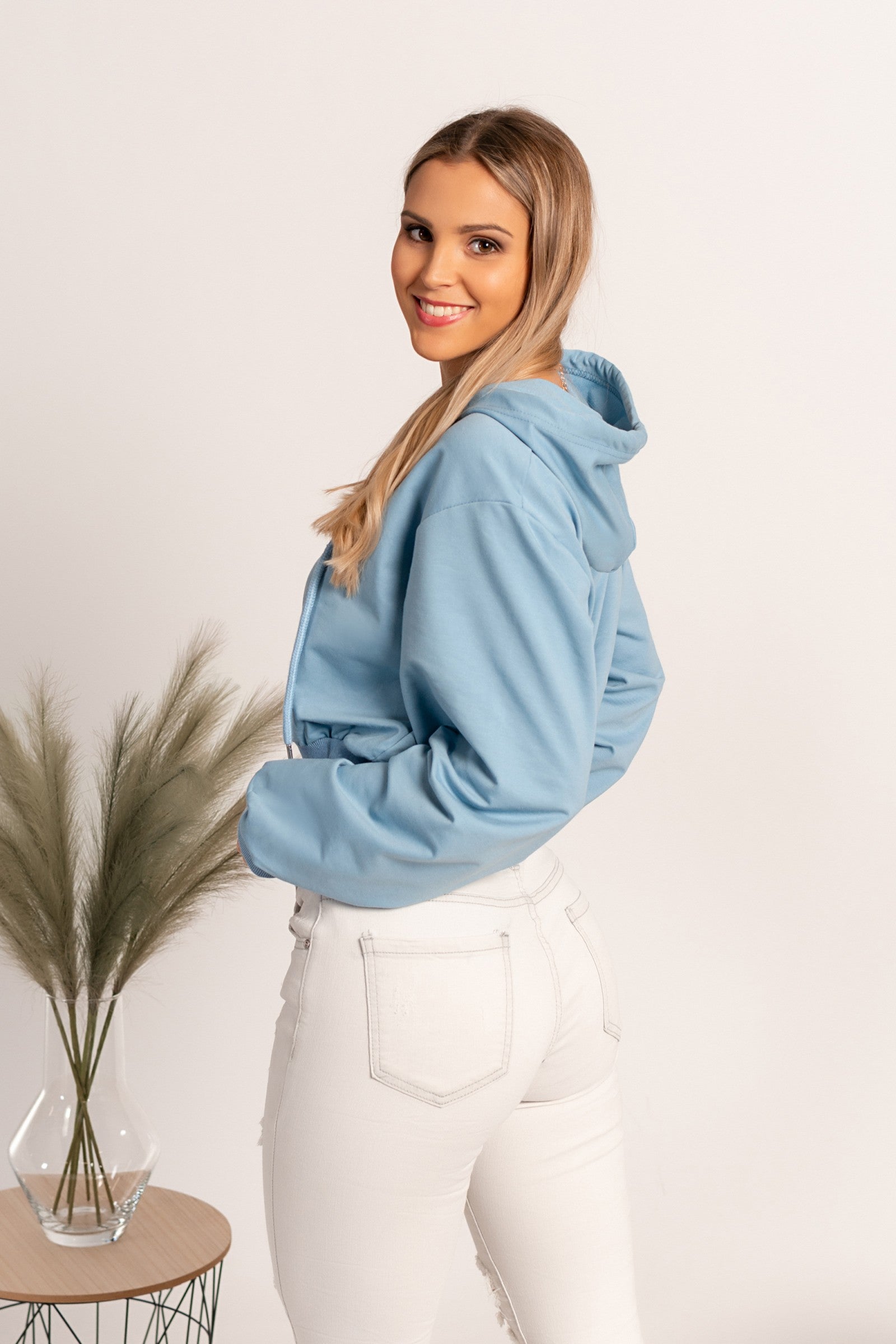 Light blue hooded sweatshirt by Belluna, featuring long sleeves and a drawstring hood, made from a soft cotton-polyester blend.