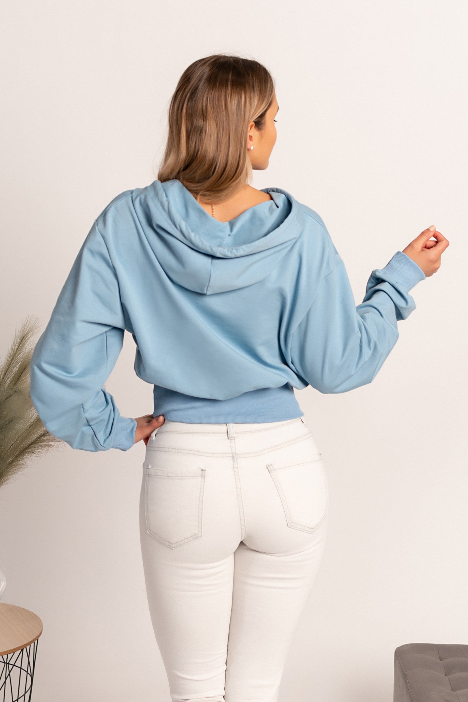 Light blue hooded sweatshirt by Belluna, featuring long sleeves and a drawstring hood, made from a soft cotton-polyester blend.