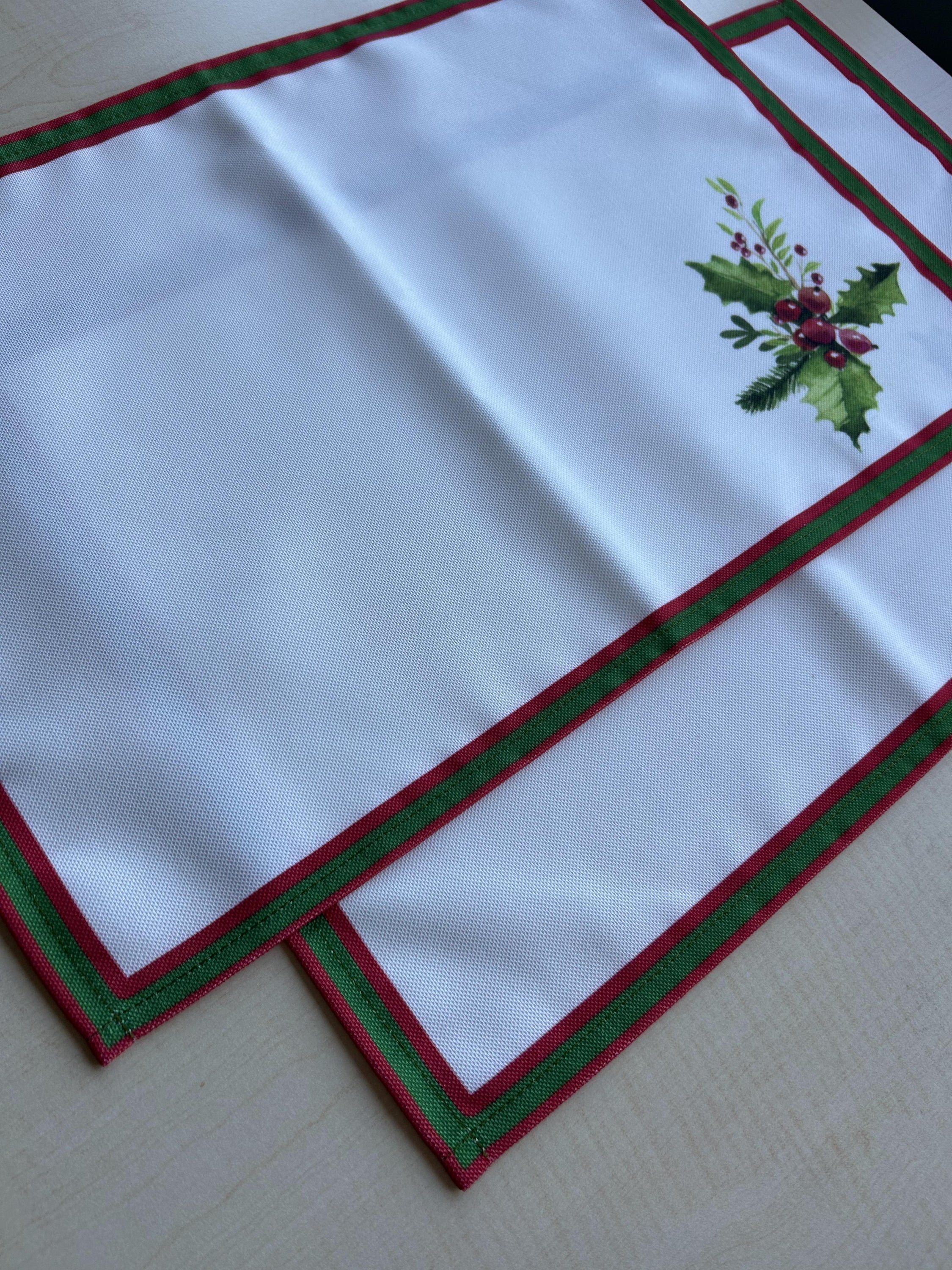 Holly Berry and Greenery Pattern Placemats on an ivory background, featuring a festive holiday design with traditional colors.