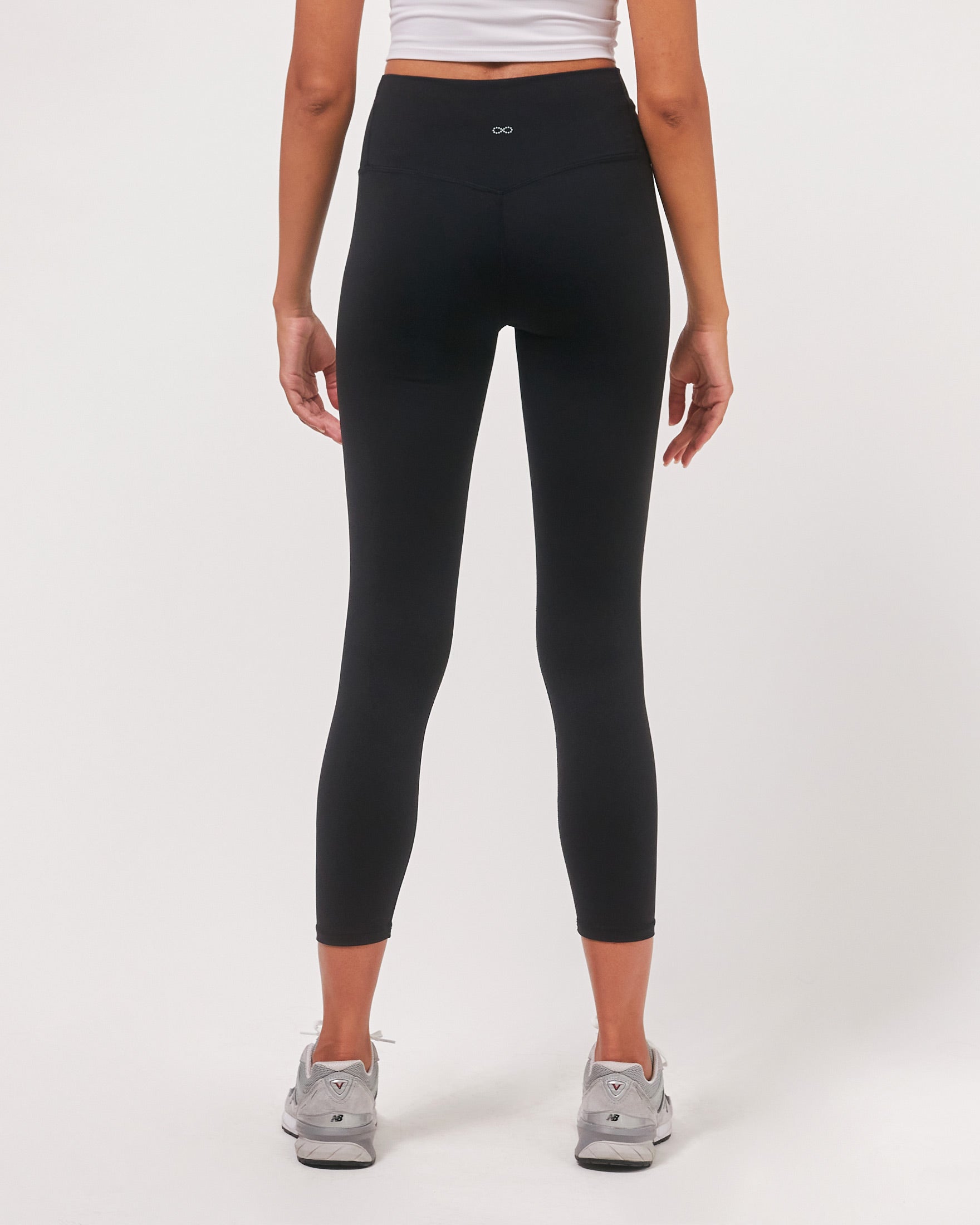 A pair of black Hybrid Cloudlux Leggings with a high waist and seamless design, showcasing V-shaped seams at the back for a flattering fit.