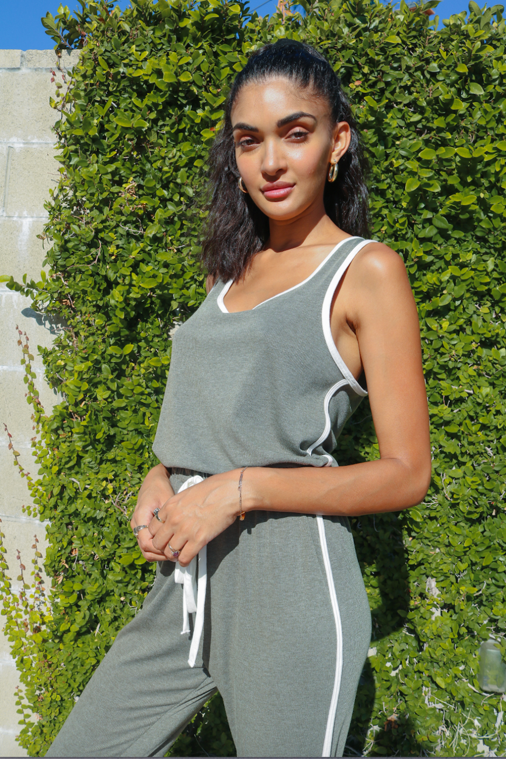 A stylish olive sleeveless jumpsuit with a high waist, made from 100% organic cotton, perfect for casual or dressy occasions.