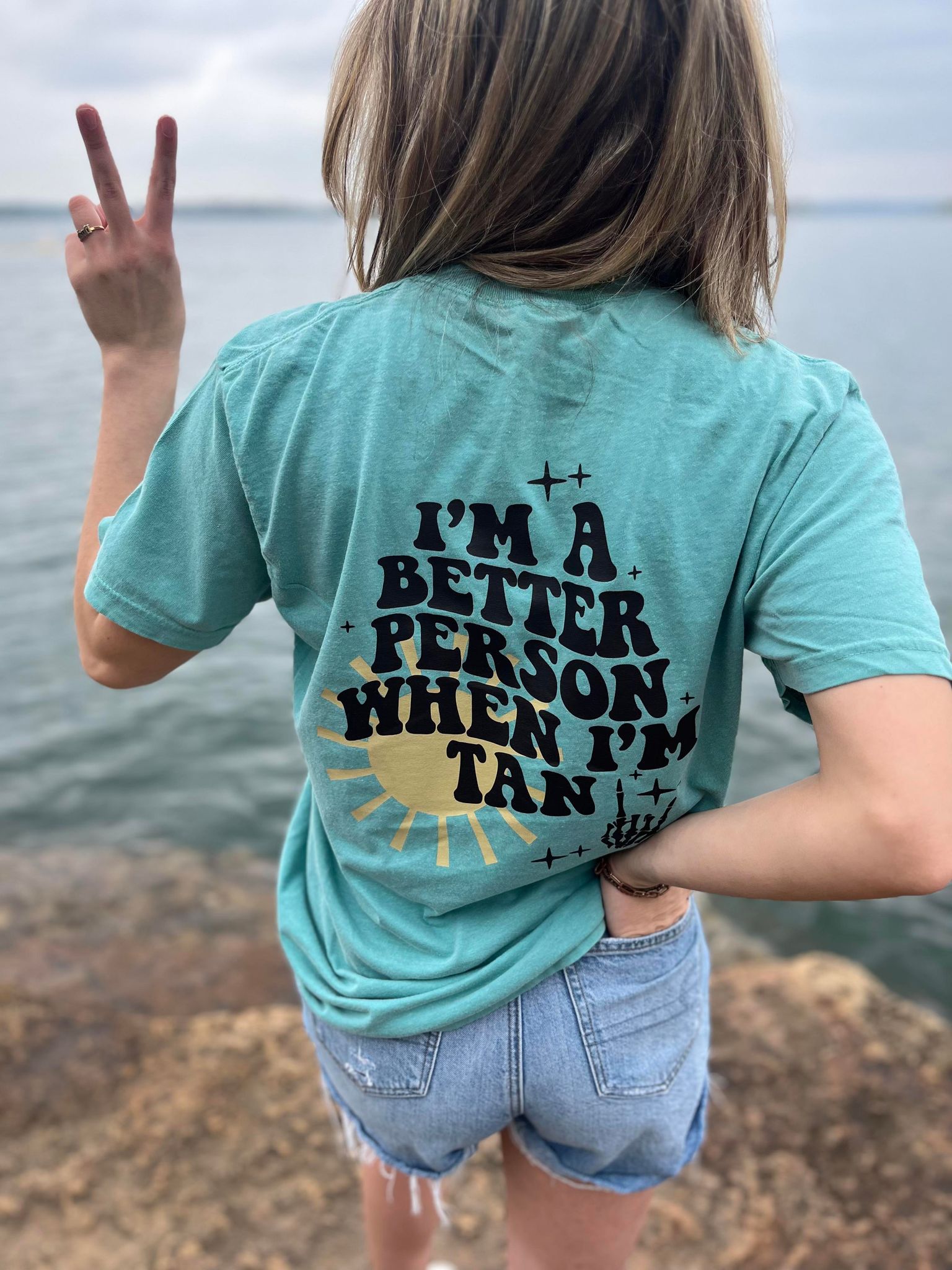 I'm A Better Person When I'm Tan Tee in Ivory and Seafoam colors, showcasing a comfortable unisex fit and vibrant DTF printed design.