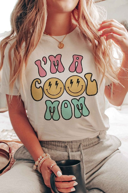 I'M A COOL MOM HAPPY FACE GRAPHIC TEE featuring a cheerful happy face design, made from 100% cotton, available in various sizes.