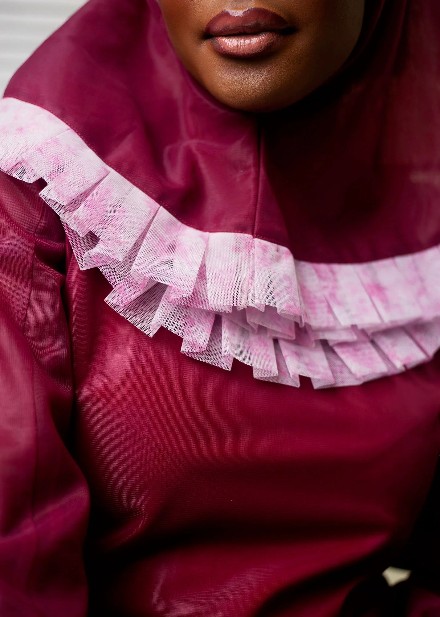 Iman Dress featuring luxurious wine tulle fabric with long sleeves and ruffles, accompanied by a matching hijab.