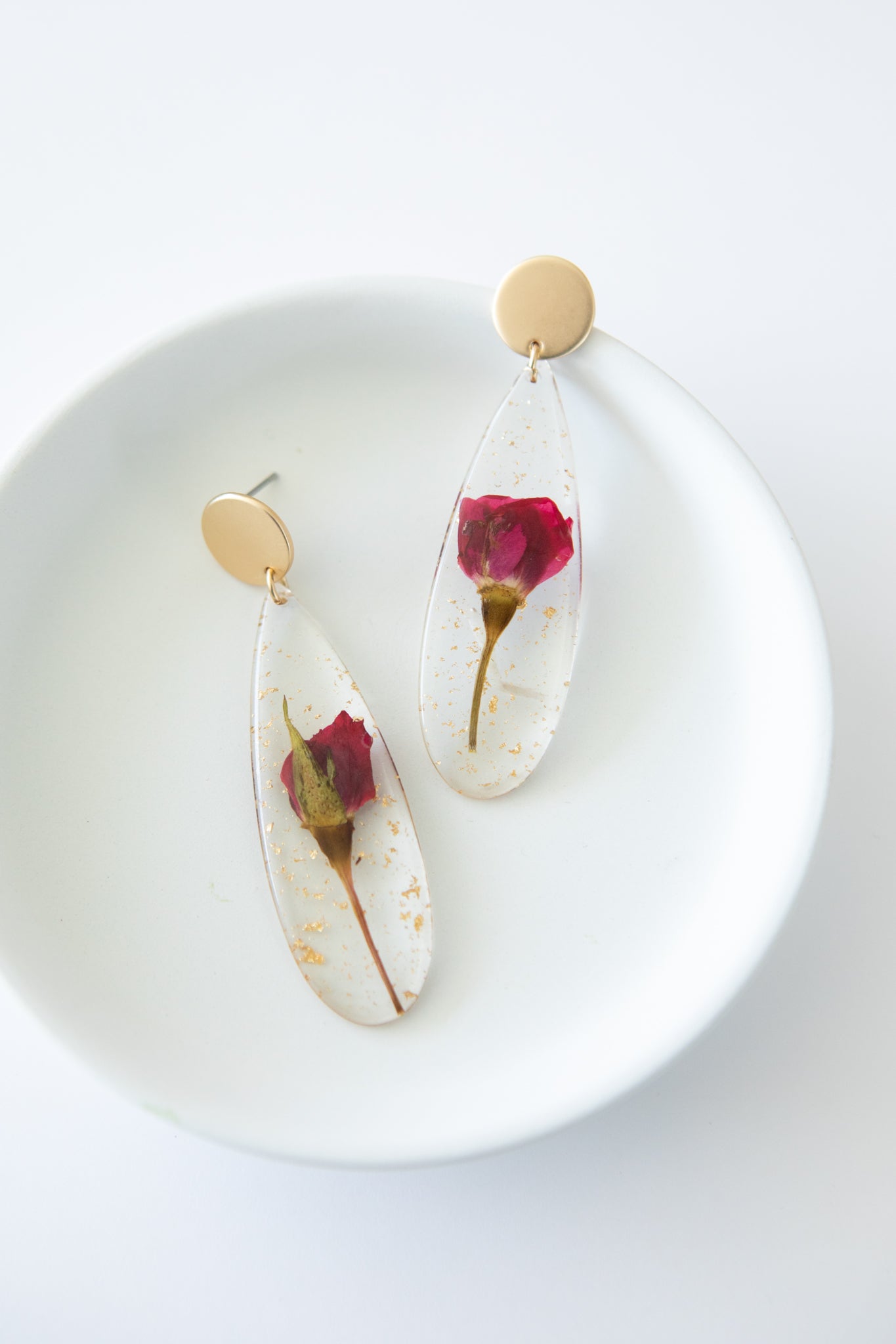 A pair of Impressively Pressed Earrings in Cardinal featuring unique floral designs encased in translucent tear drop shapes.